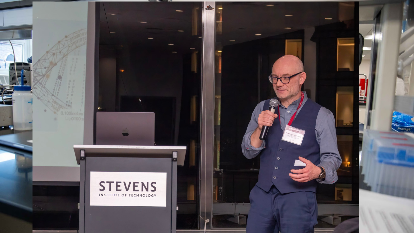 Marcin Iwanicki addresses a crowd by a Stevens podium.