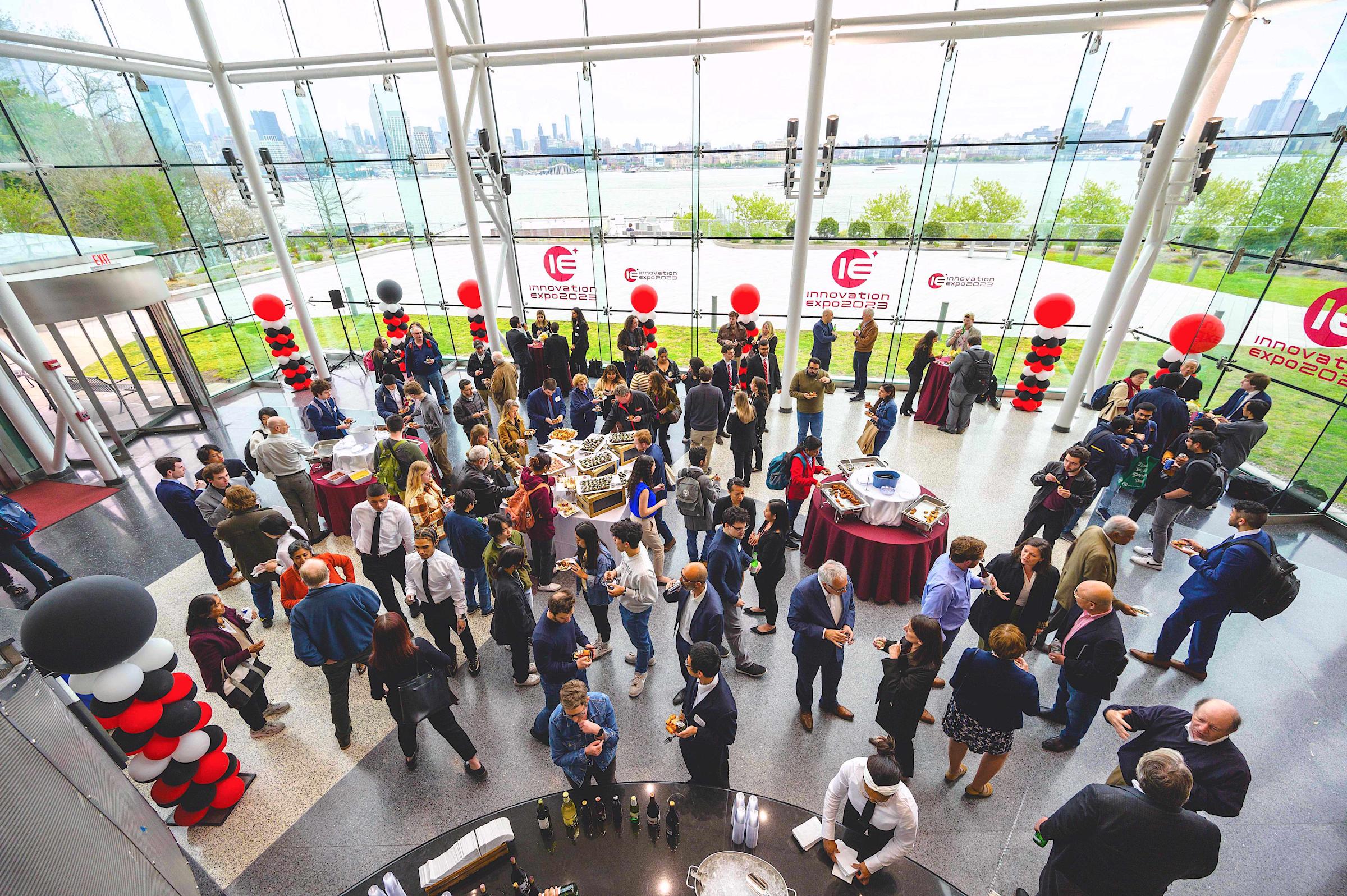 Room full of 2023 Innovation Expo attendees overlooking the Hudson River and Manhattan skyline