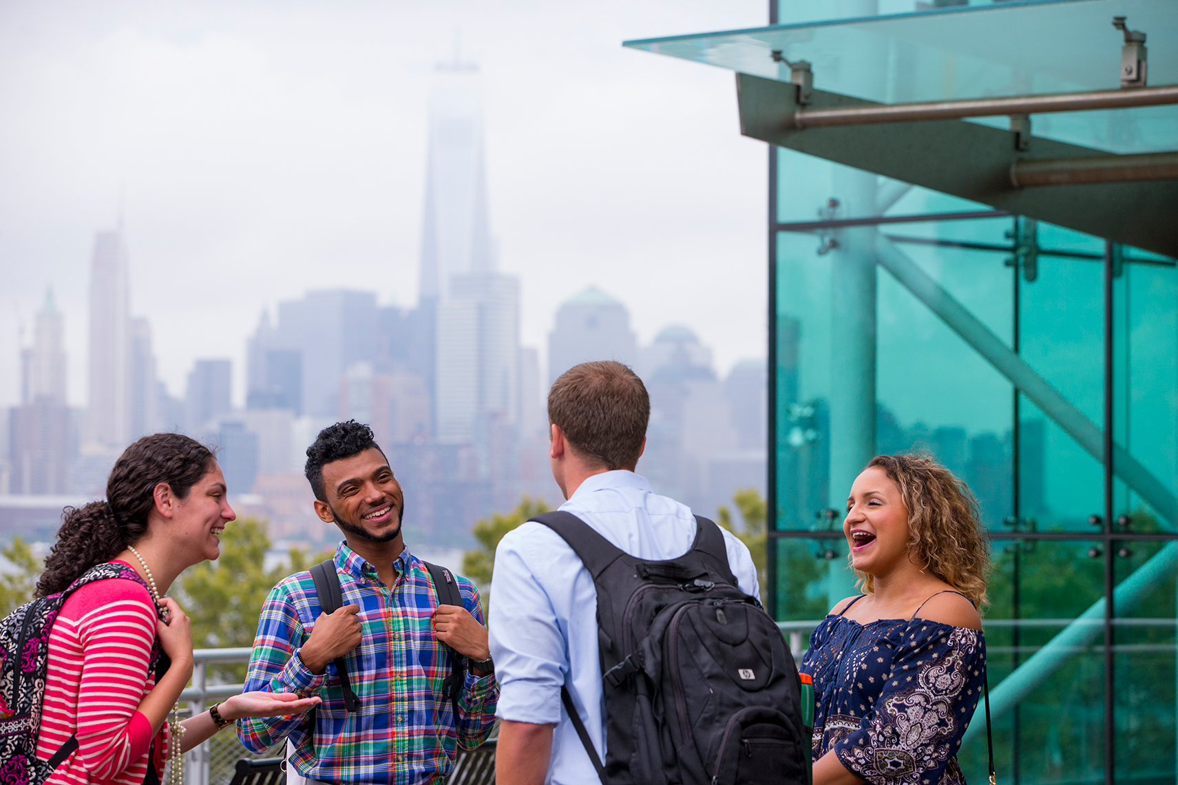 4 students laughing outside of Babbio Building