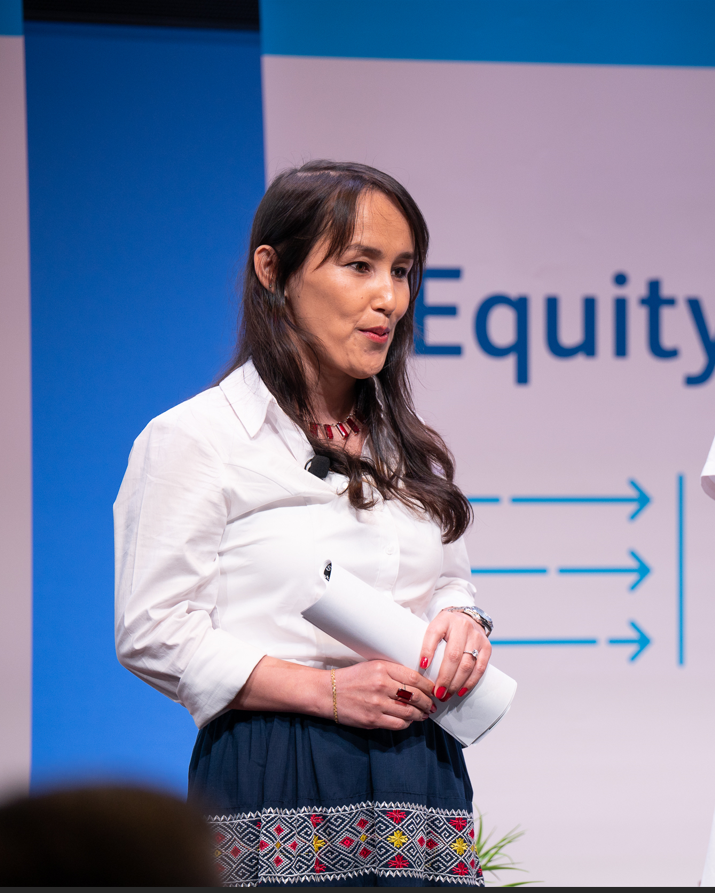 Gullnaz Saeedi talks to an audience from a stage. 
