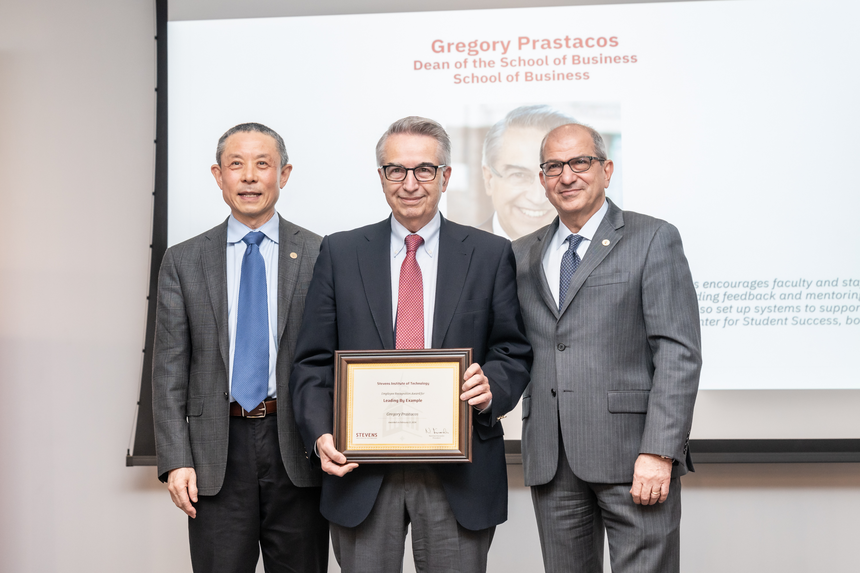 Gregory Prastacos holds his award flanked by Jianmin Qu on the left and Naramin Farvardin on the right.
