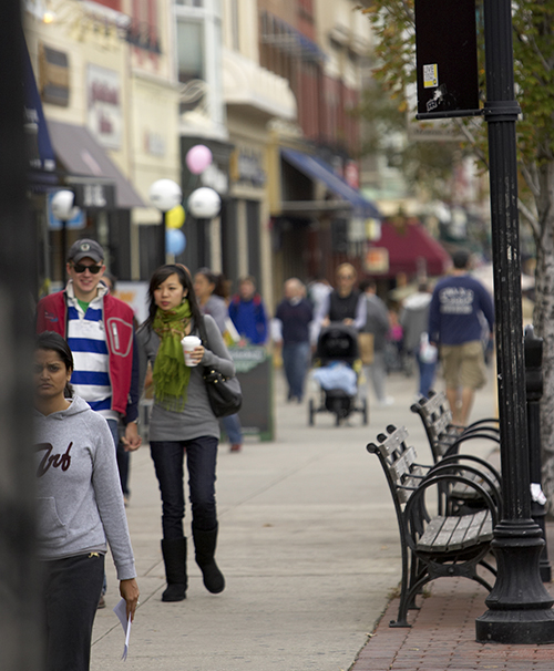 A couple walking amongst others on a busy street in Hoboken
