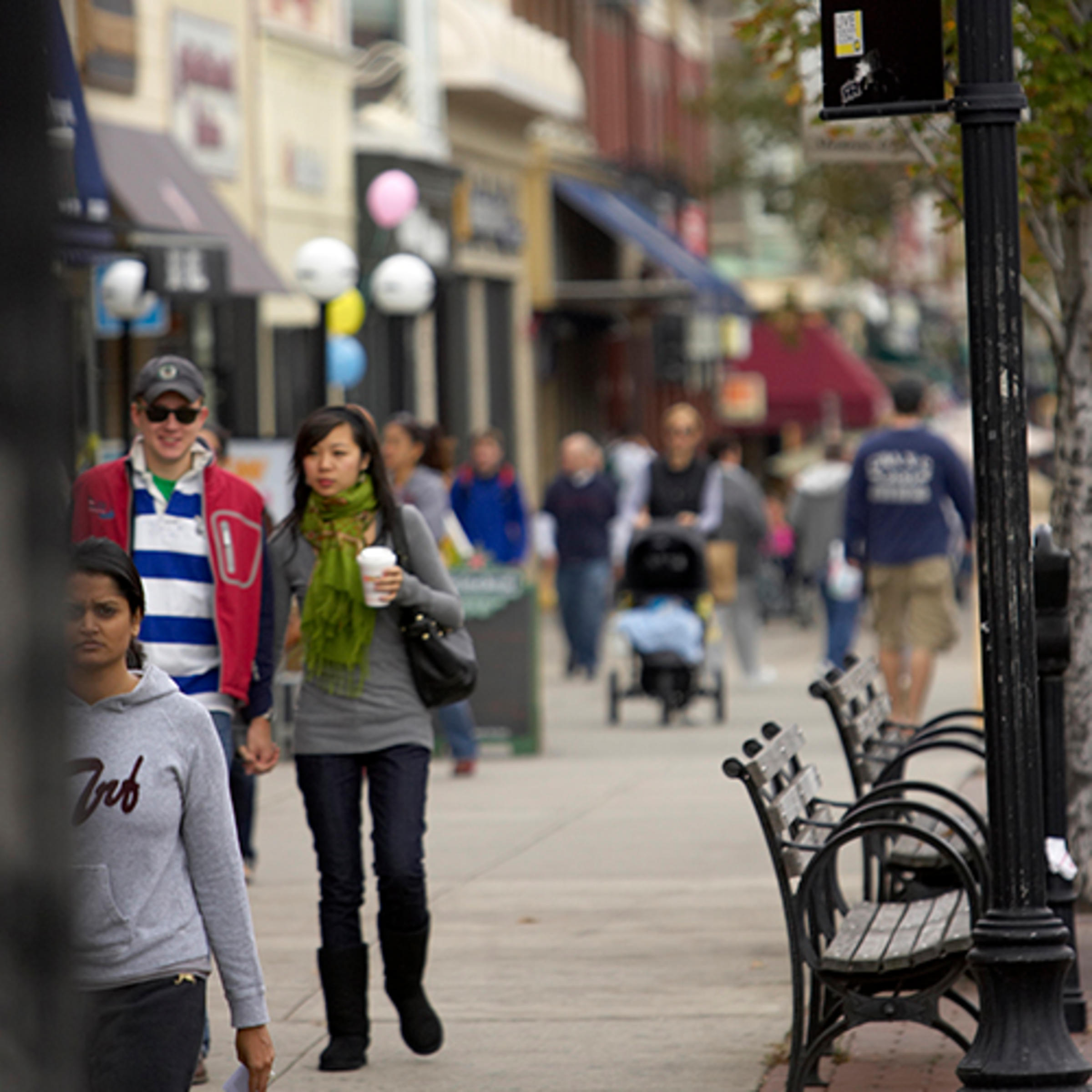 A couple walking amongst others on a busy street in Hoboken