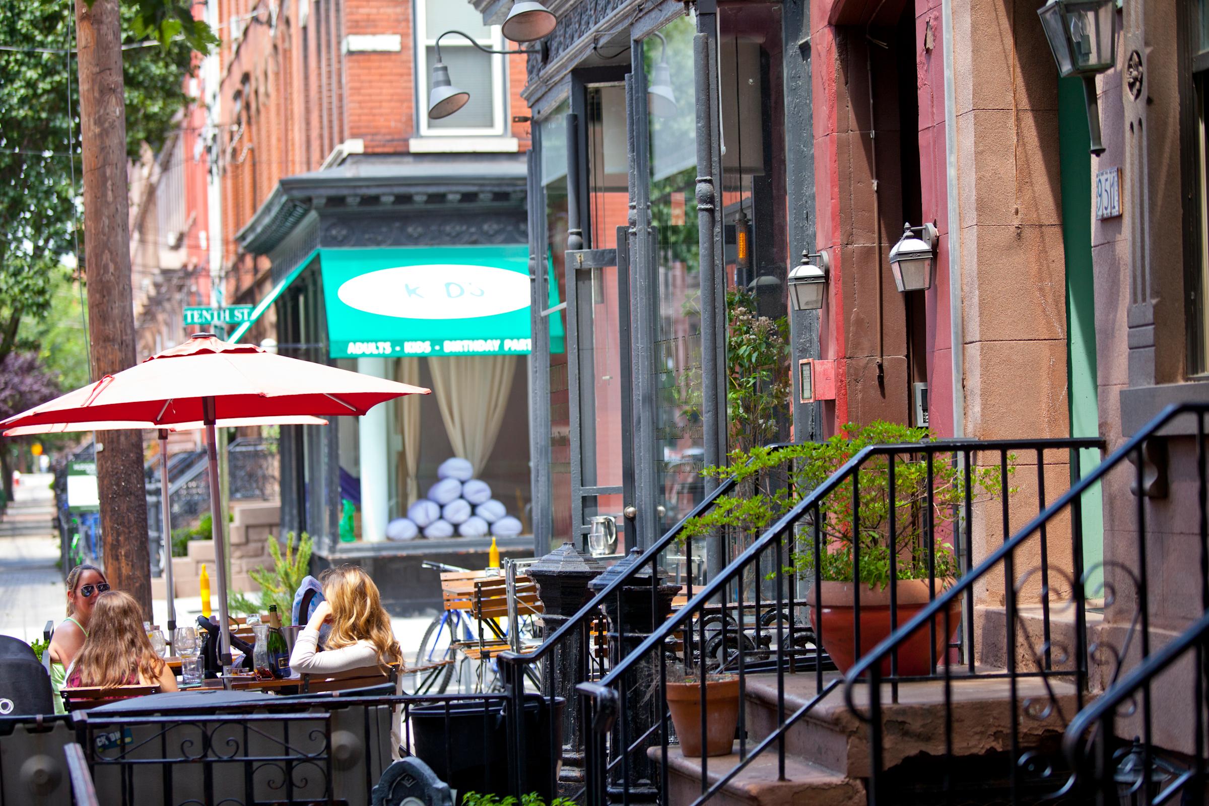 Patrons sitting outside a corner cafe in Hoboken.