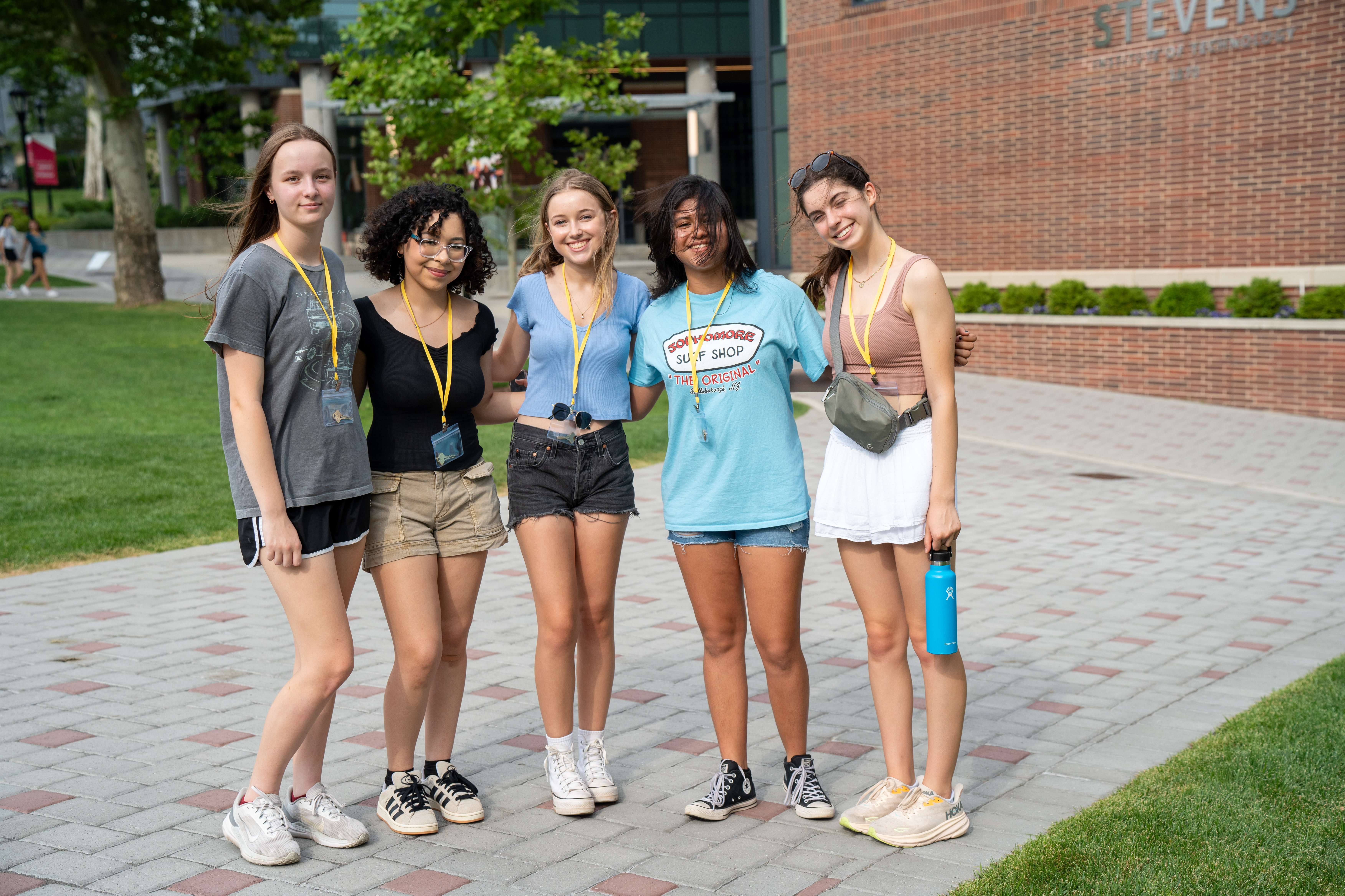 a group of five pre-college students on campus smiling for the camera