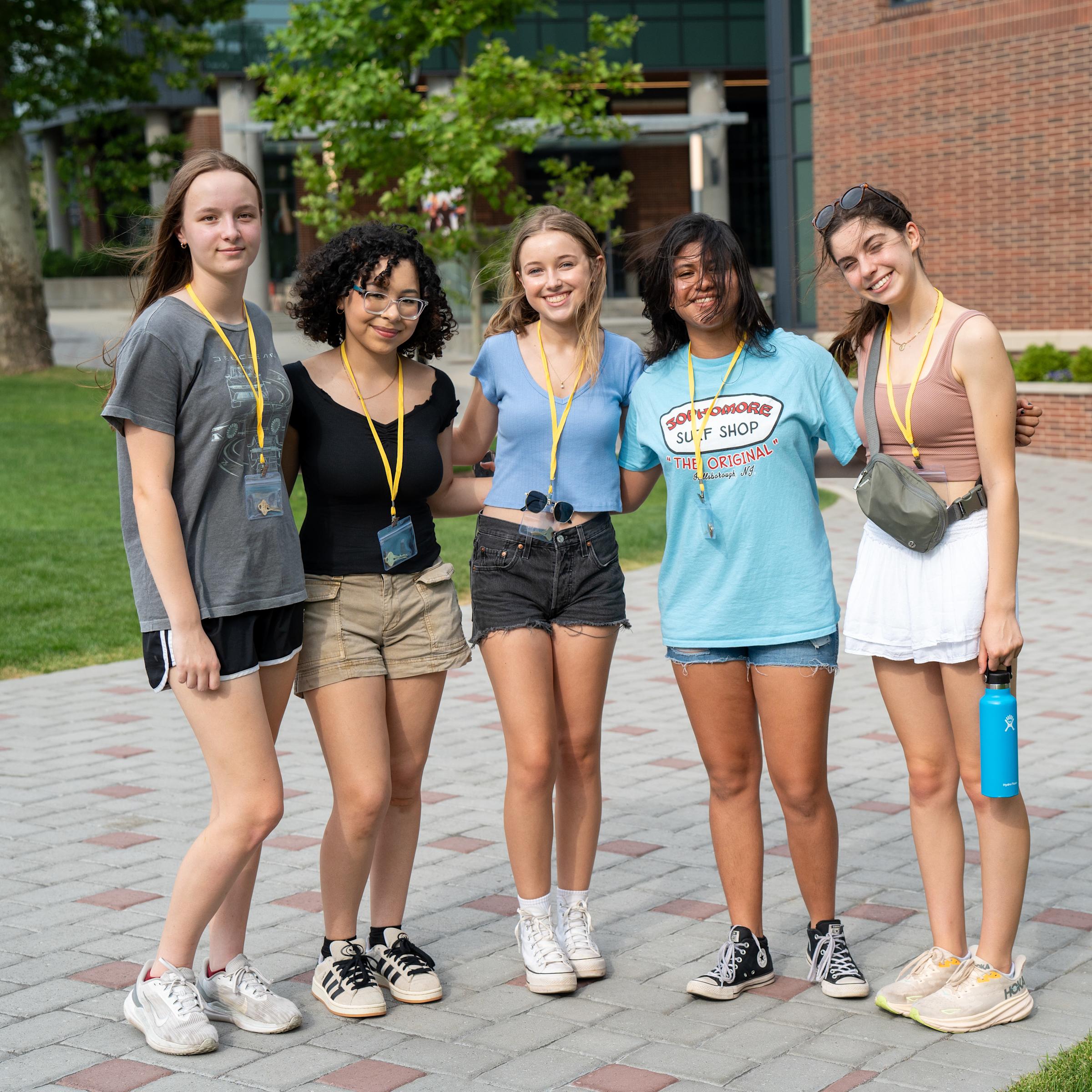 a group of five pre-college students on campus smiling for the camera