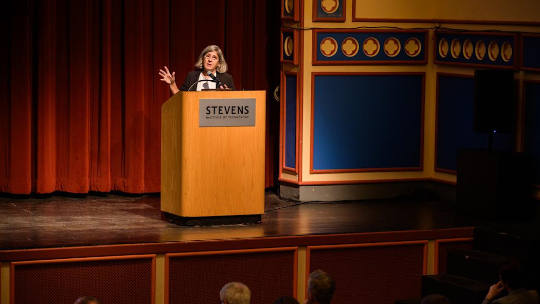 Manuela Veloso, Ph.D. Head of AI Research, JPMorgan Chase & Co. speaks from behind a podium on a stage.