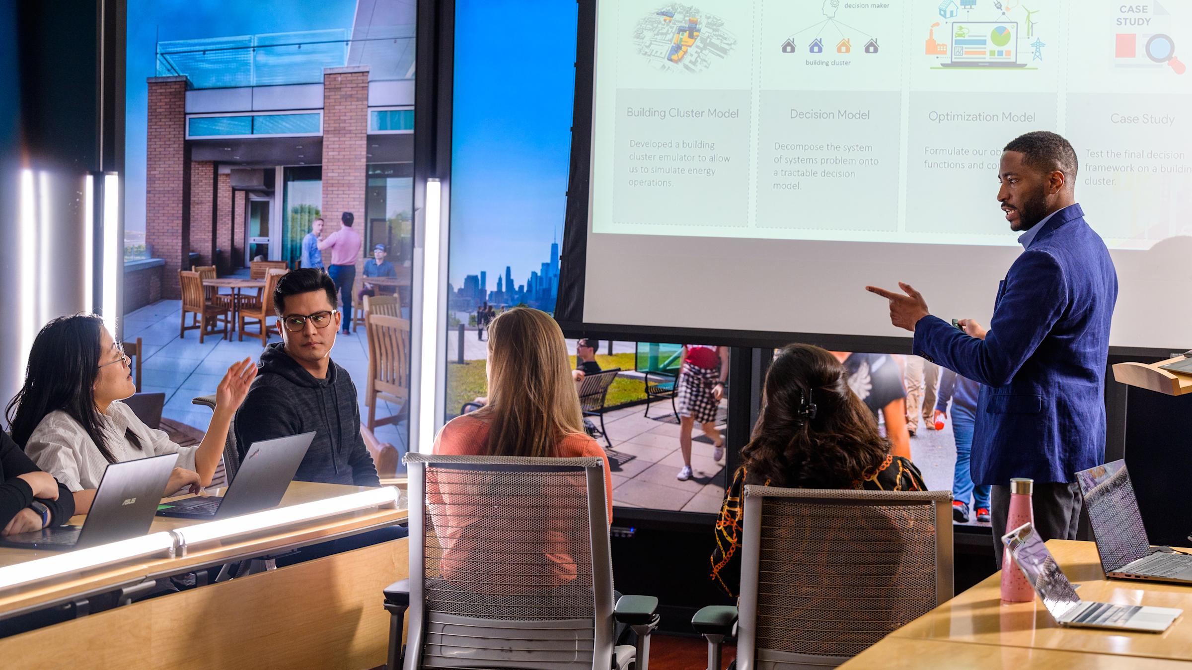 Students gather in a classroom with professor
