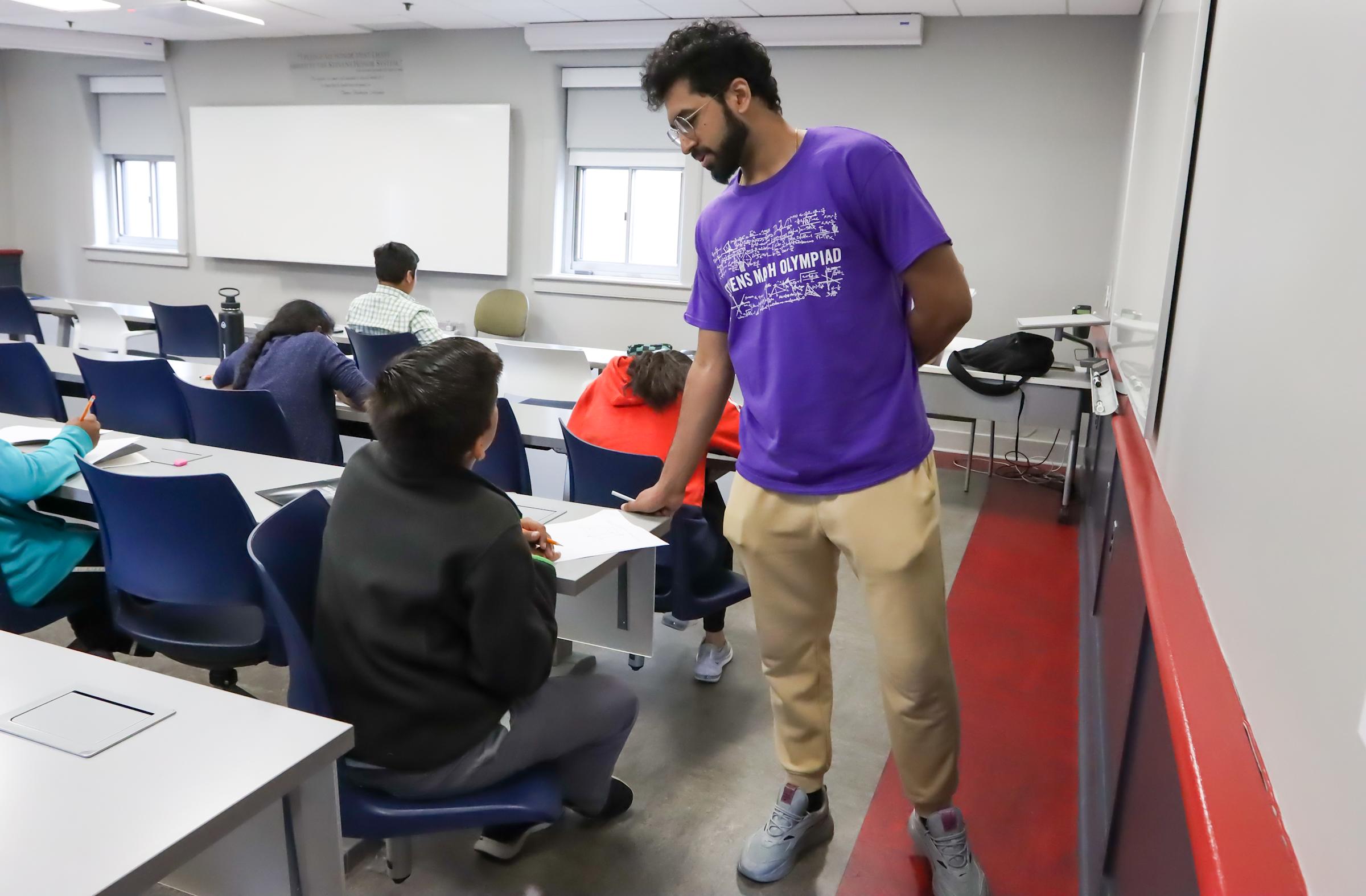 Math Olympiad volunteer assisting student with exam question