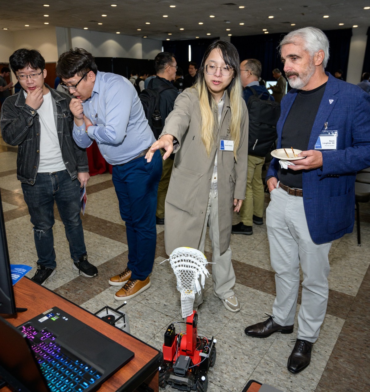 Students and professionals examine poster and phsycial presentations.