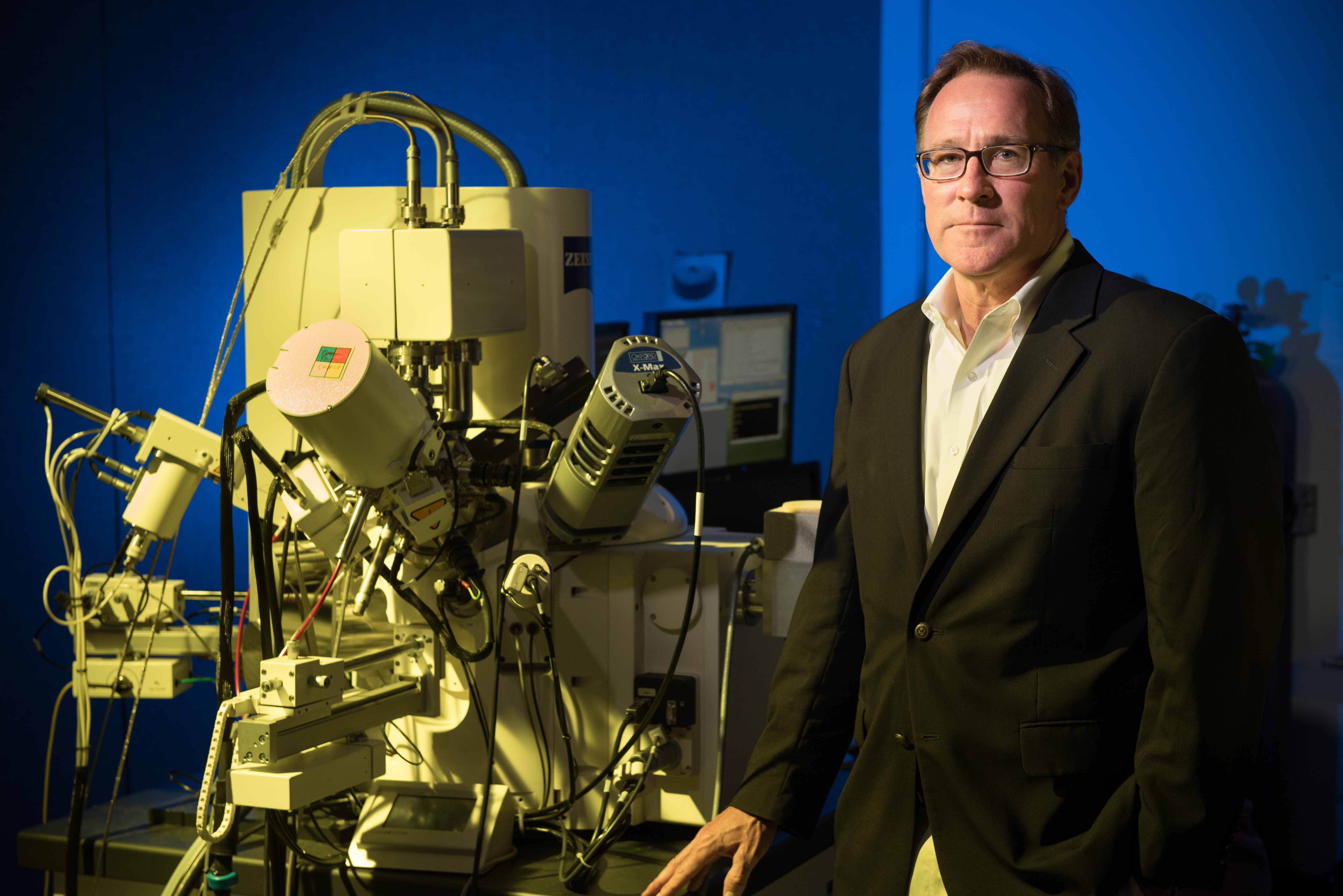 Professor Matt Libera stands next to a large piece of lab equipment.