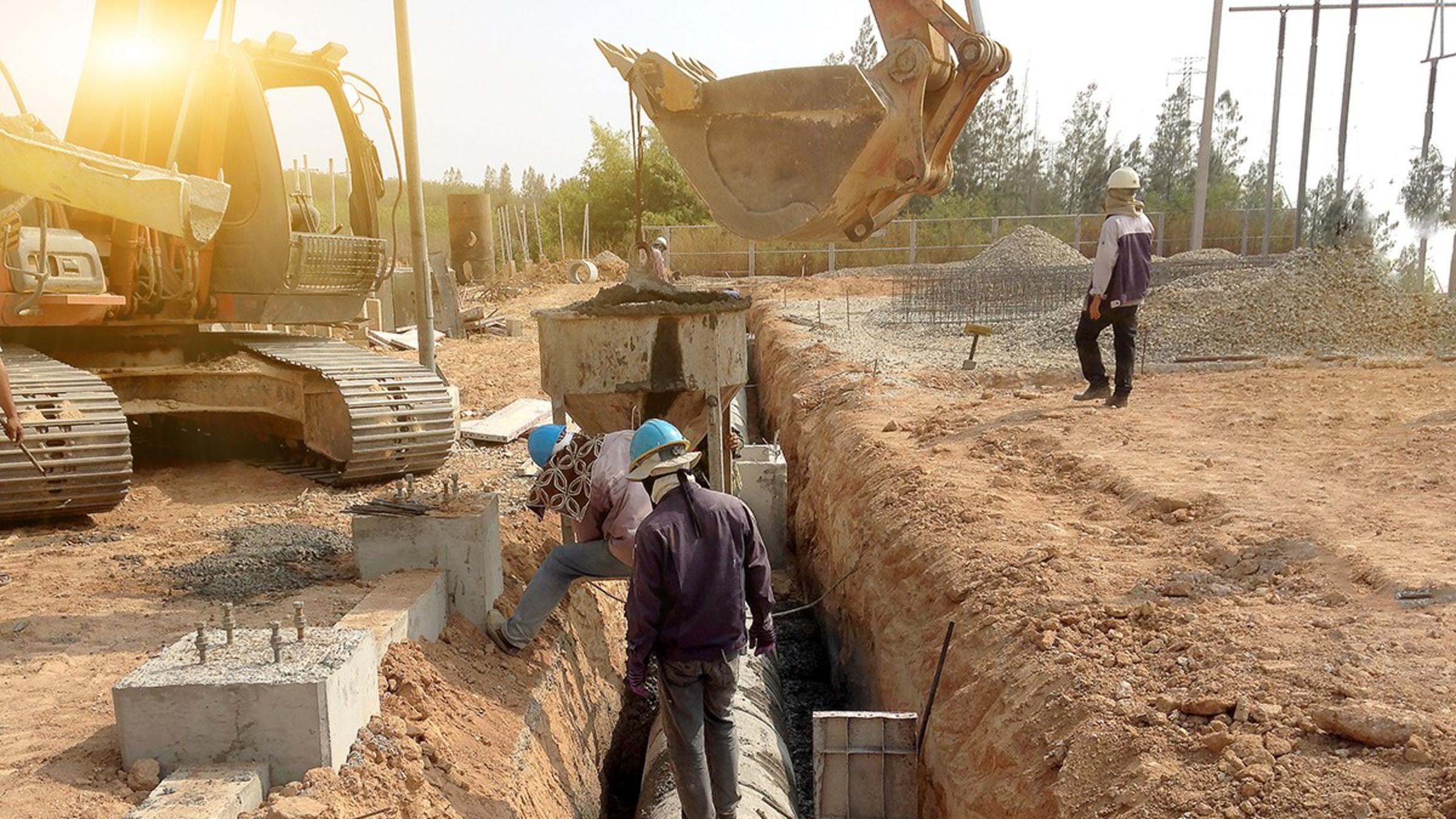 A dirt trench with a large pipe running through it.