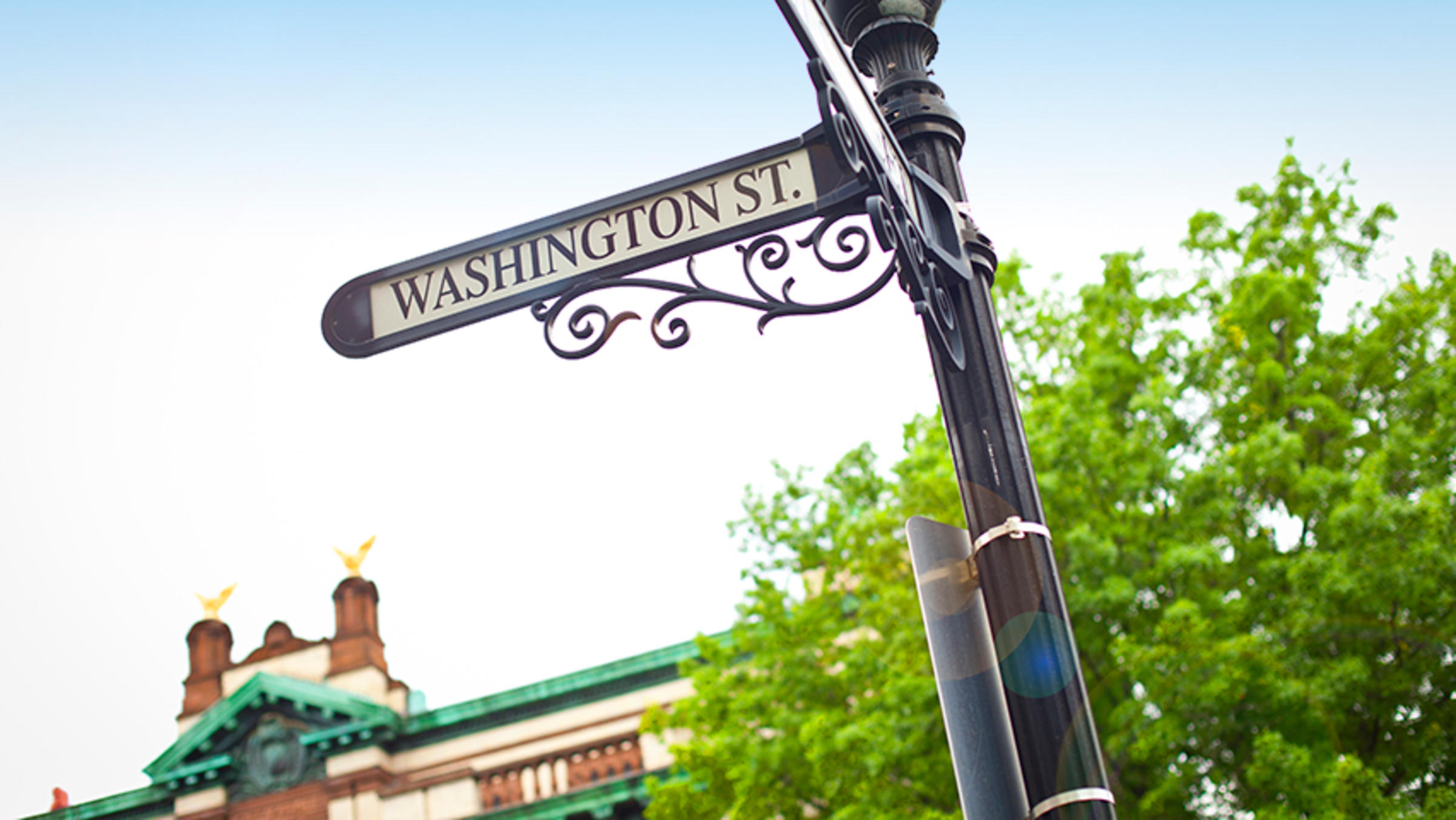 Street sign on Washington Street, Hoboken, with City Hall visible in background.
