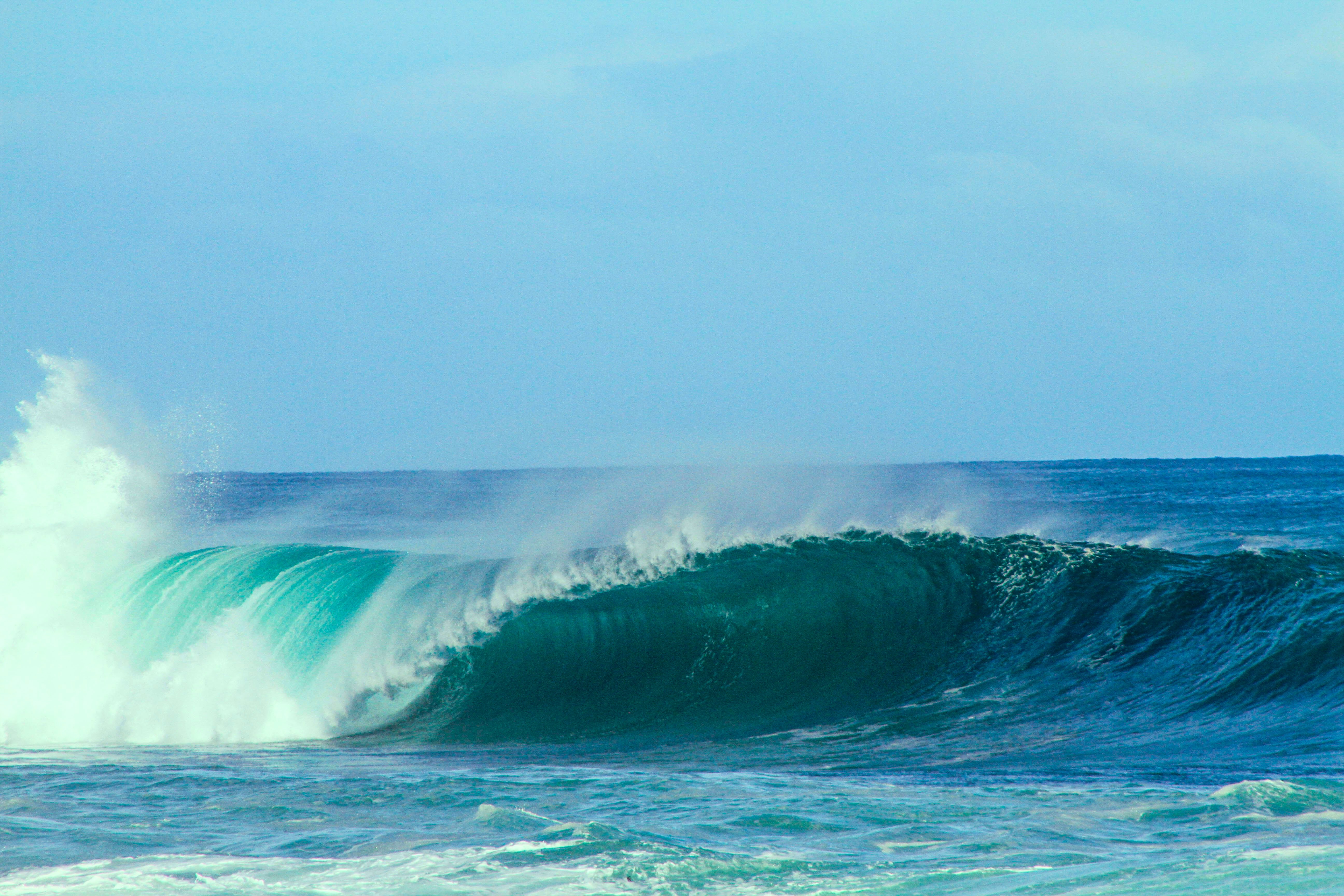 A blue breaking wave in the ocean, representing wave power
