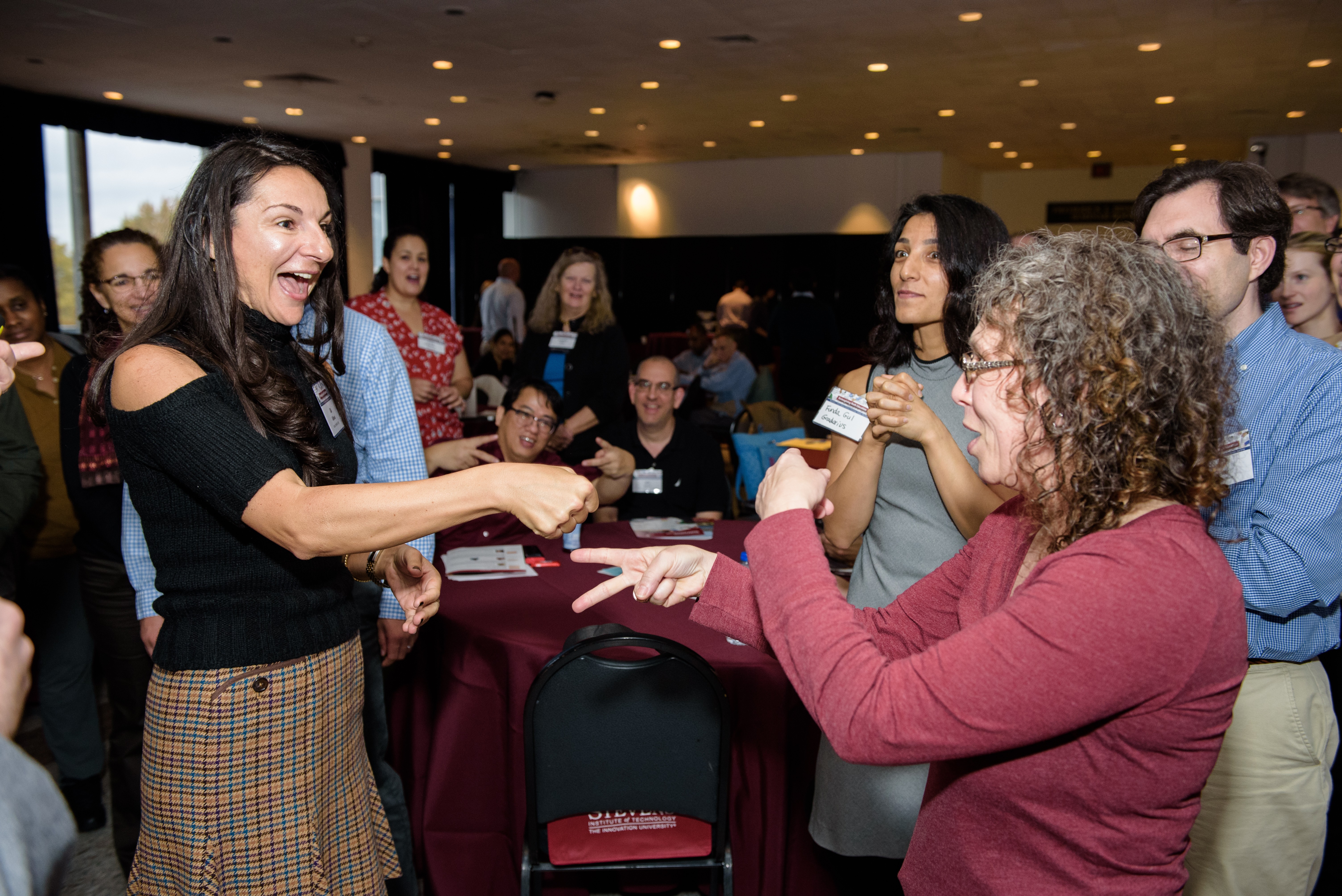 CAPTION: participants engage in a rock—paper—scissors tournament at the Reimagining Math Education conference. CREDIT: Jeff Vock