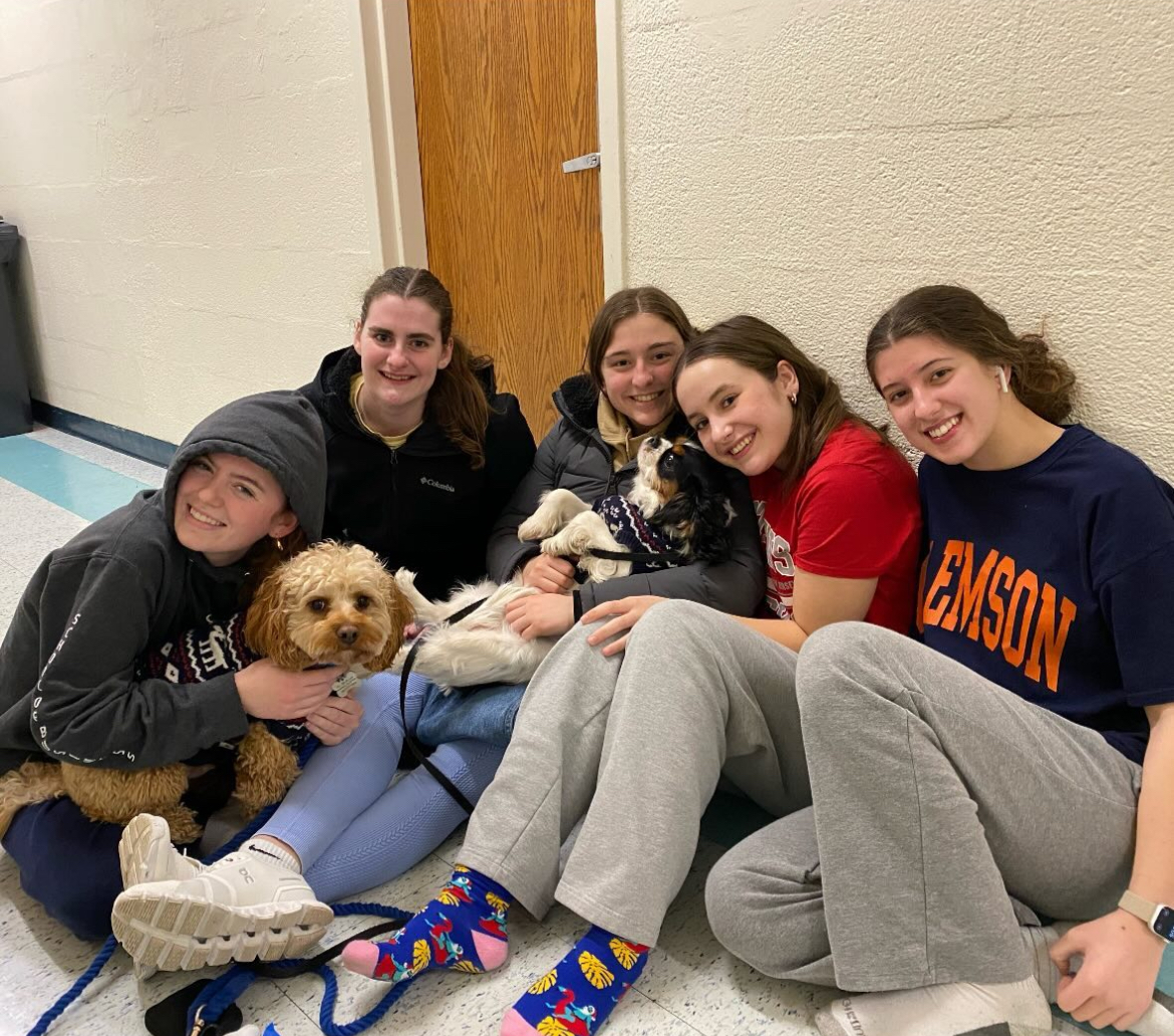 Faith Bet and friends smile sitting on the ground together