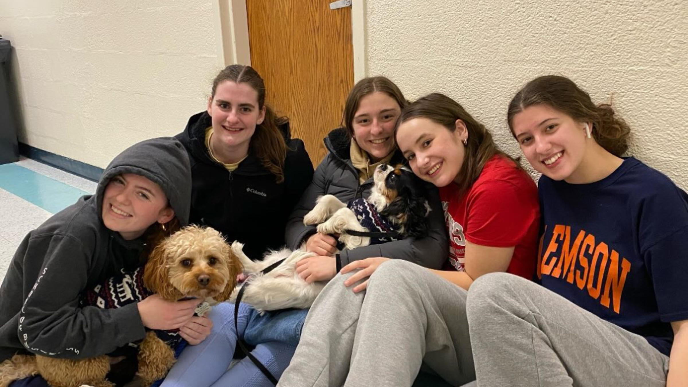 Faith Bet and friends smile sitting on the ground together