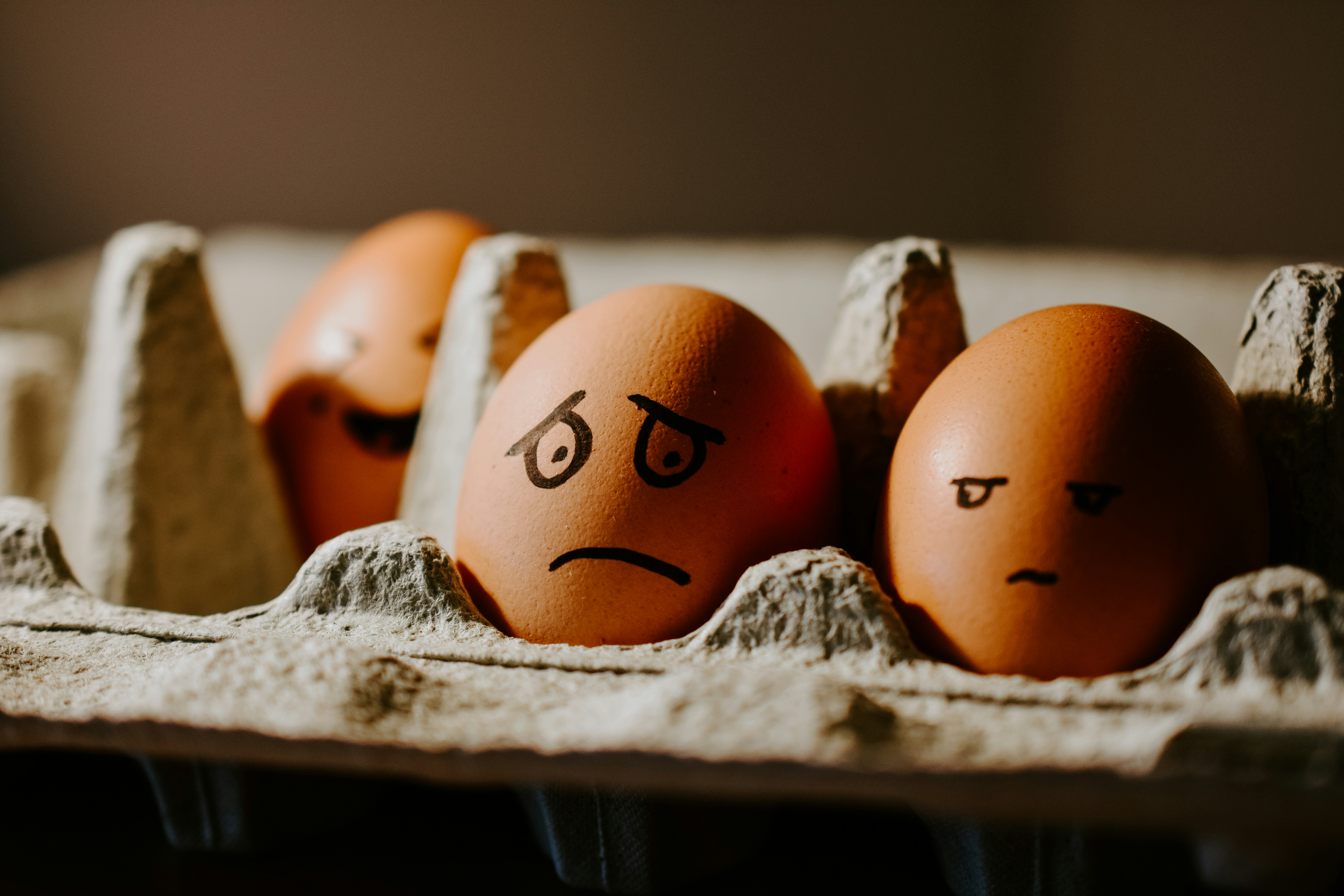 Carton of eggs with sad eyes marked onto them, signifying depression