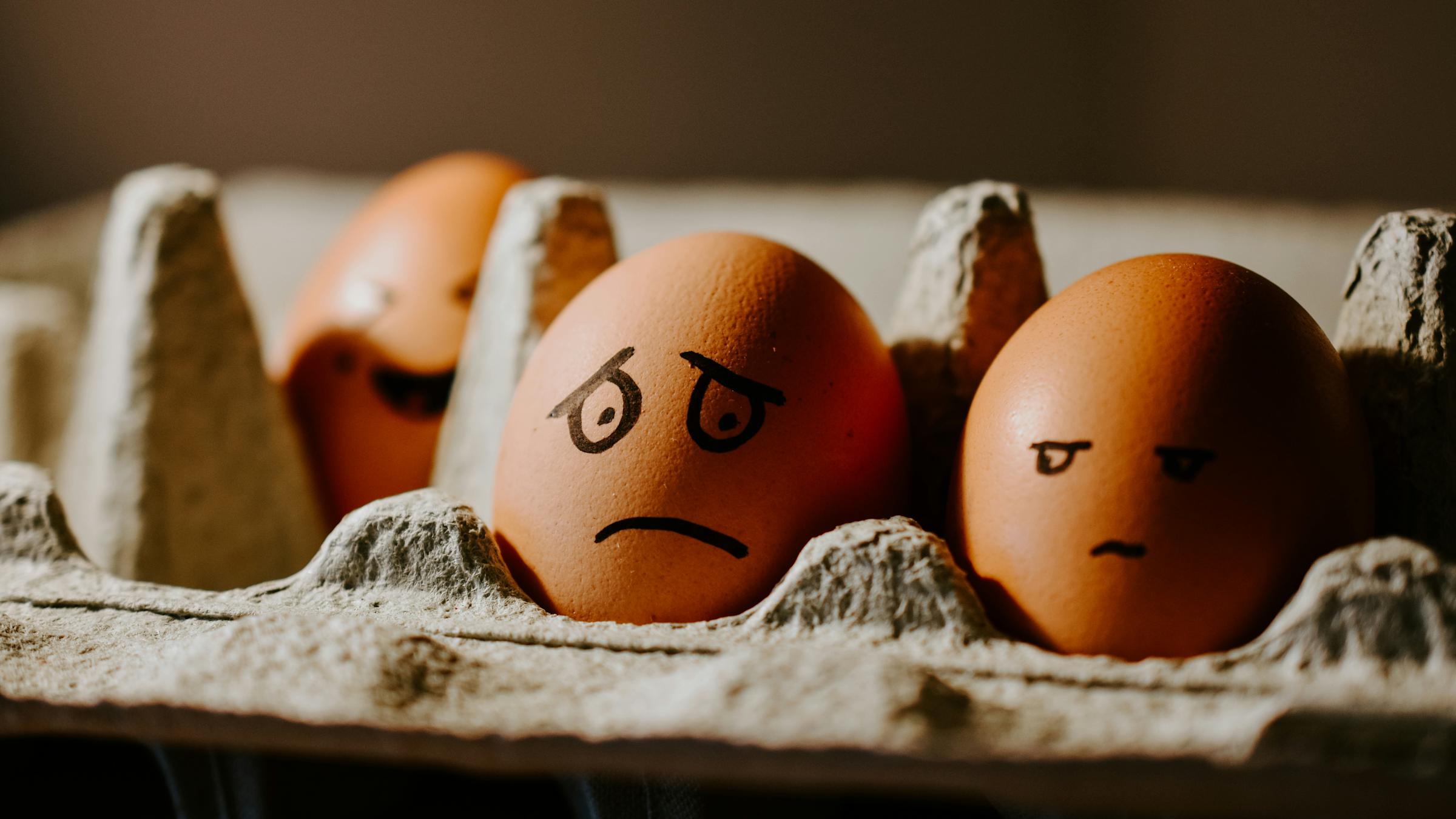 Carton of eggs with sad eyes marked onto them, signifying depression