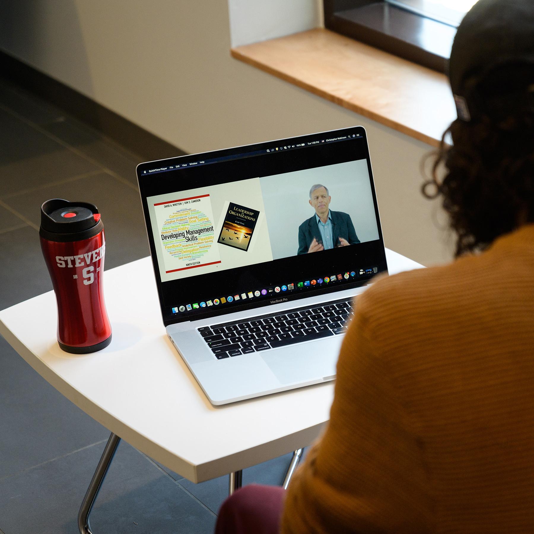 Student attending an online lecture on their laptop
