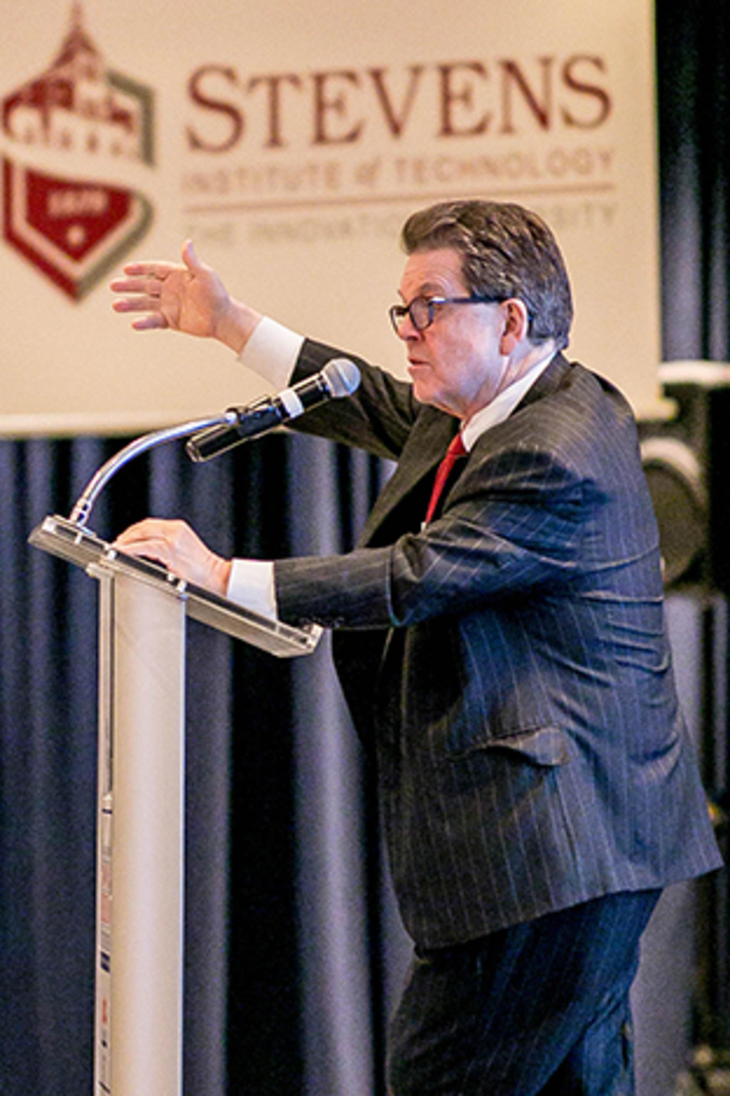 Dr. Art Laffer speaking at a podium.