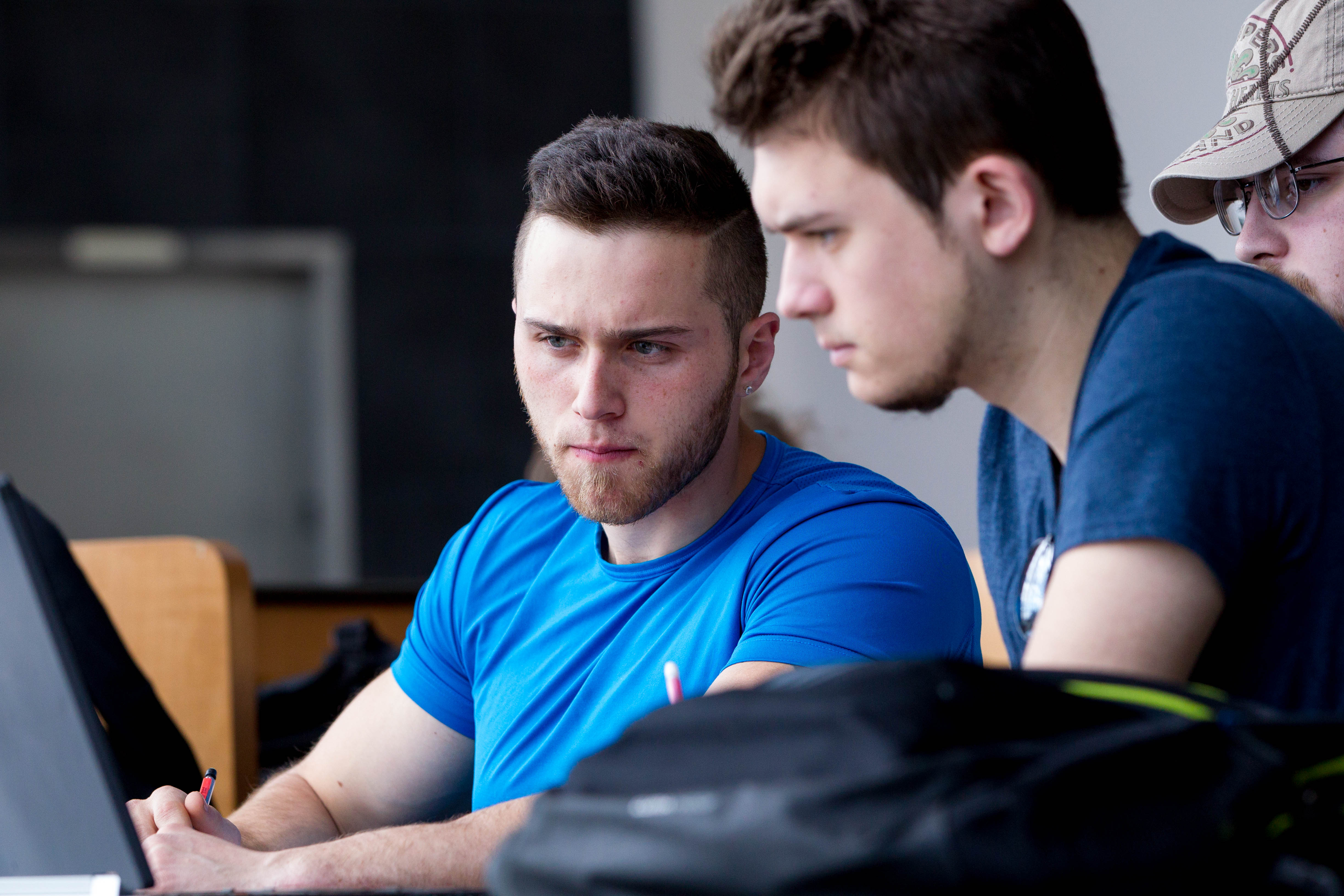 two students looking at a laptop
