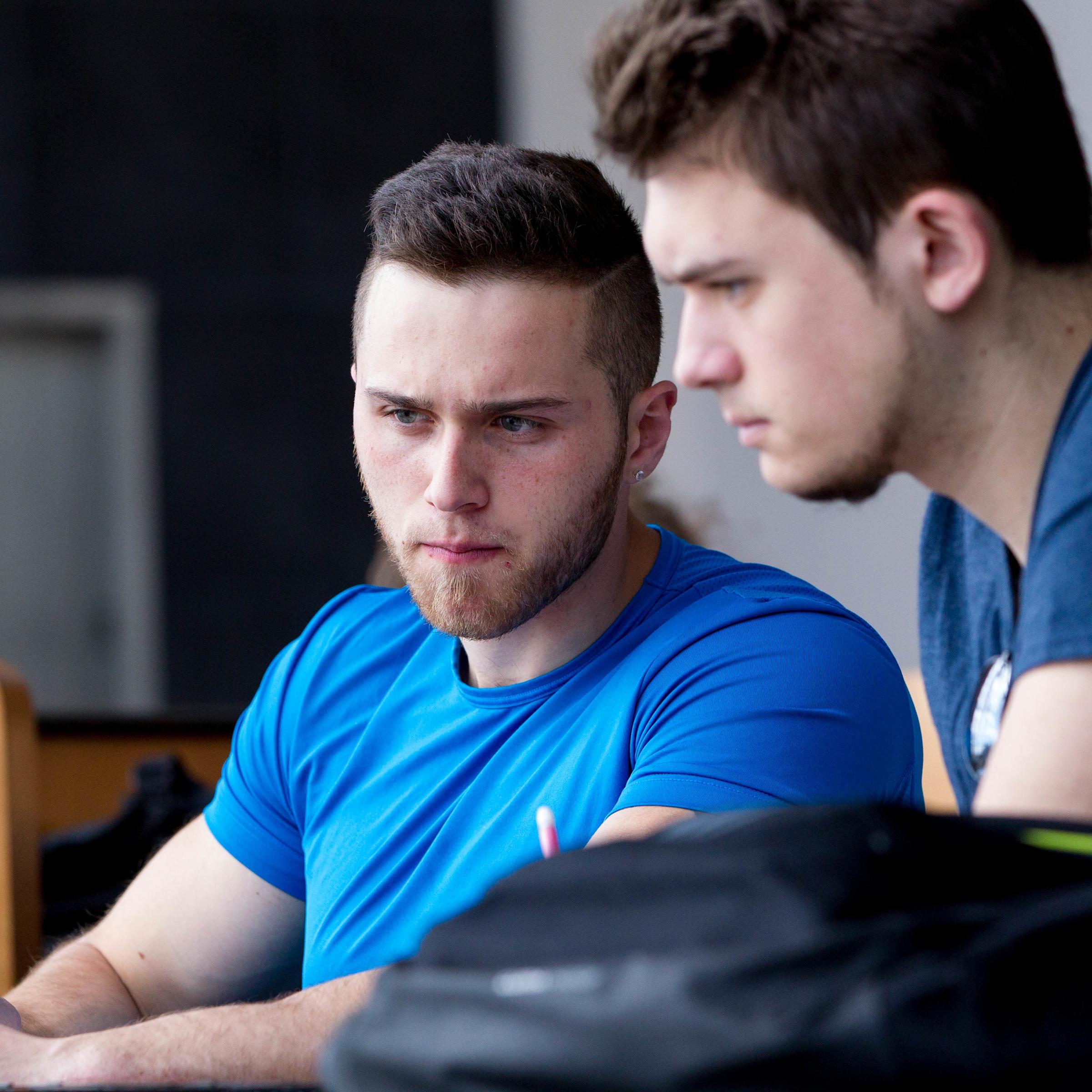 two students looking at a laptop