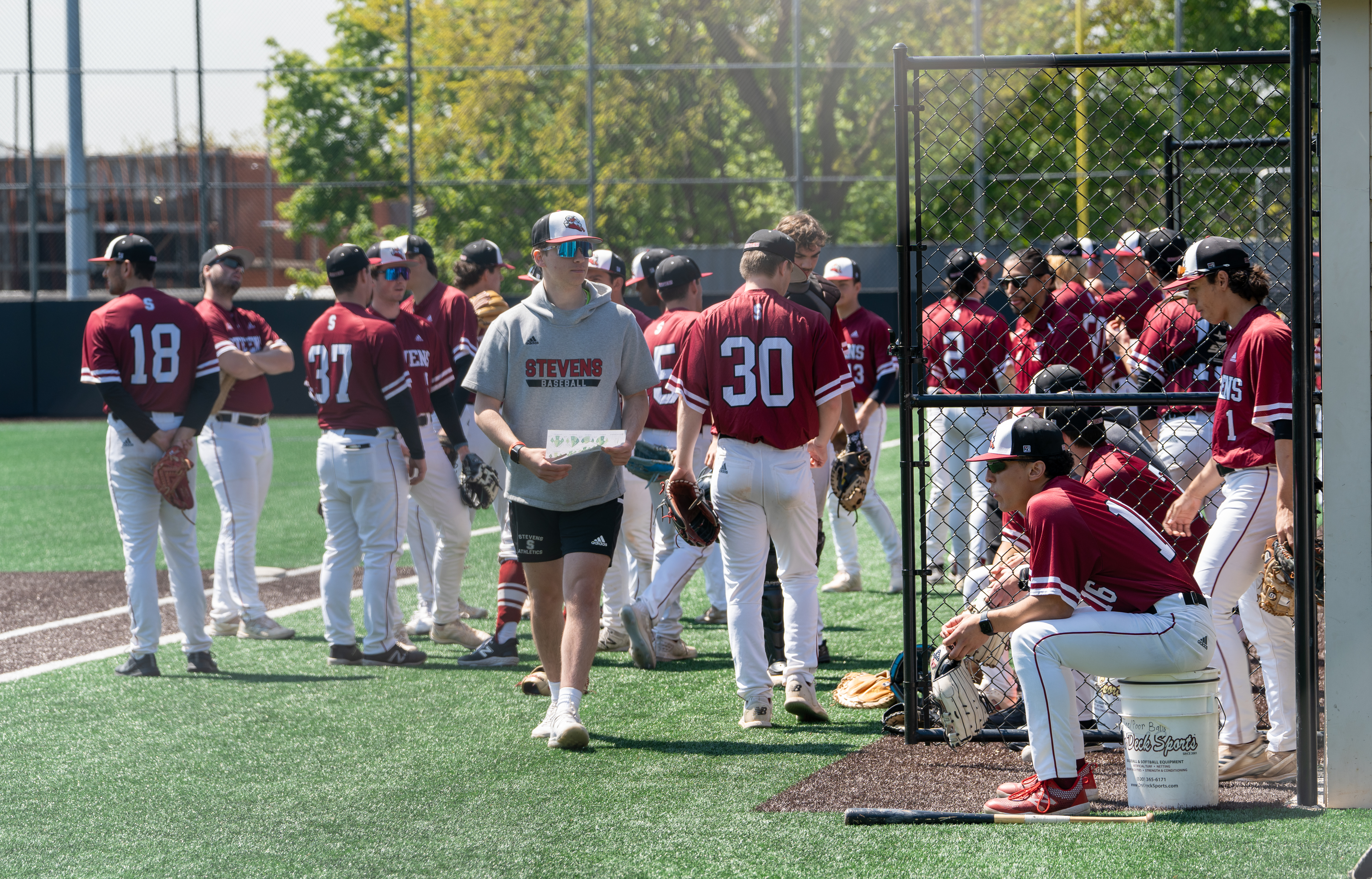 Vaughn Weber stands in the foreground of a group of Stevens baseball players on the field prior to a game.