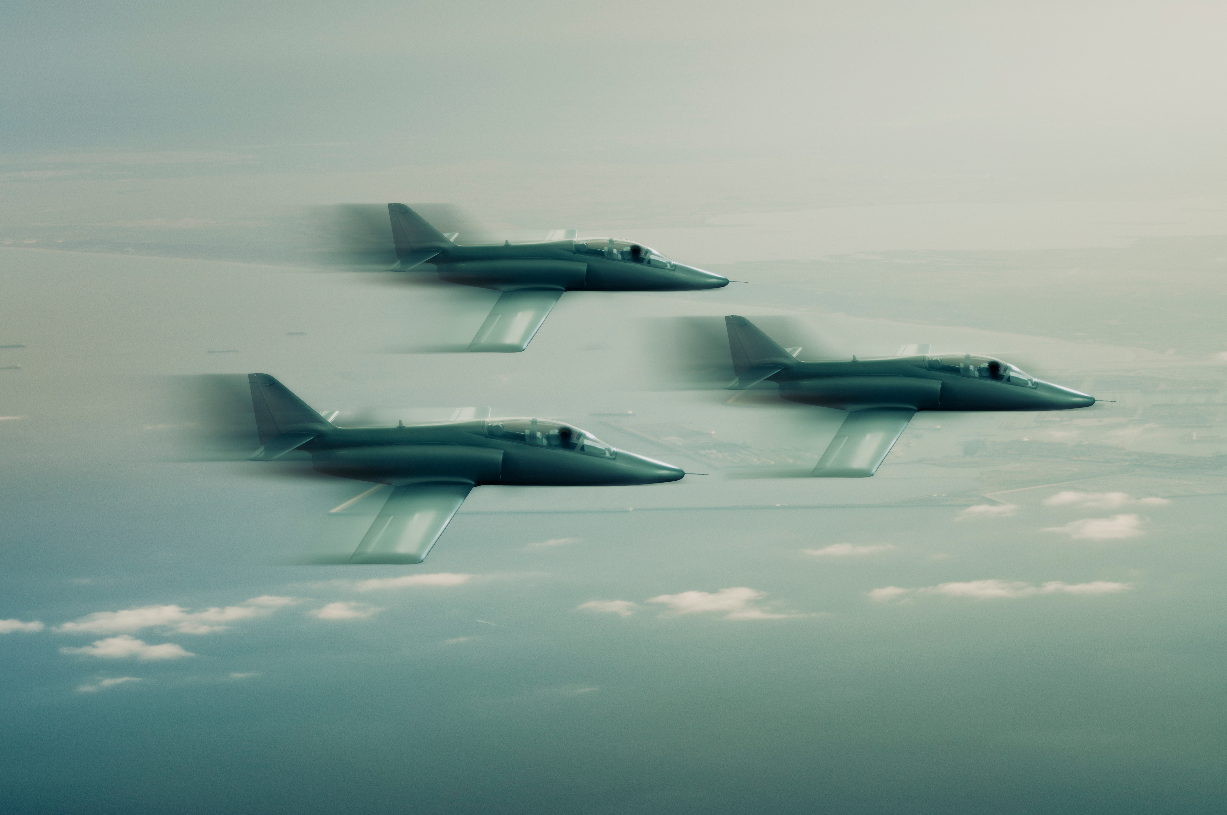 An image of three military aircraft flying together. They are blurred to give the appearance of speed.