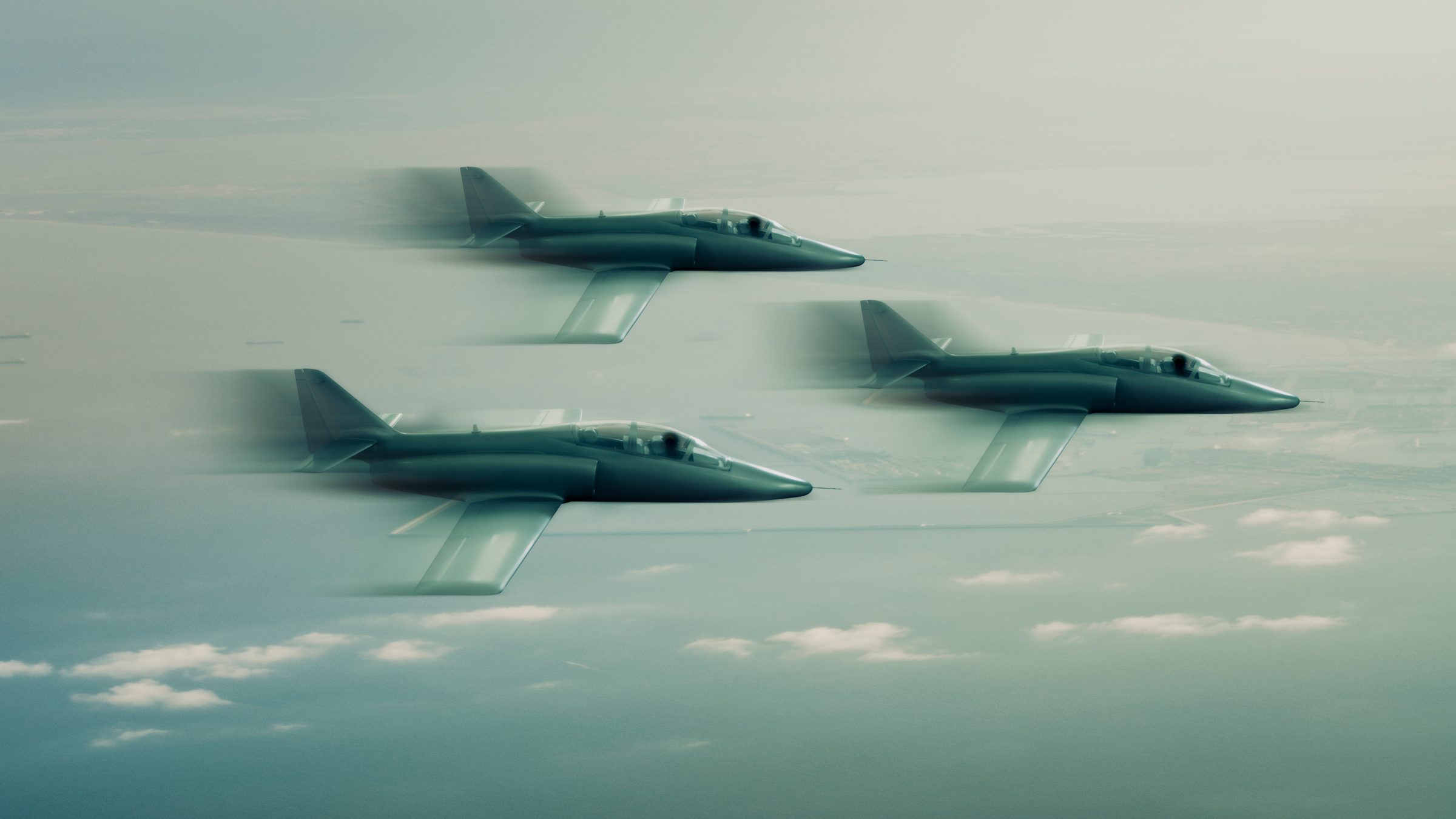 An image of three military aircraft flying together. They are blurred to give the appearance of speed.