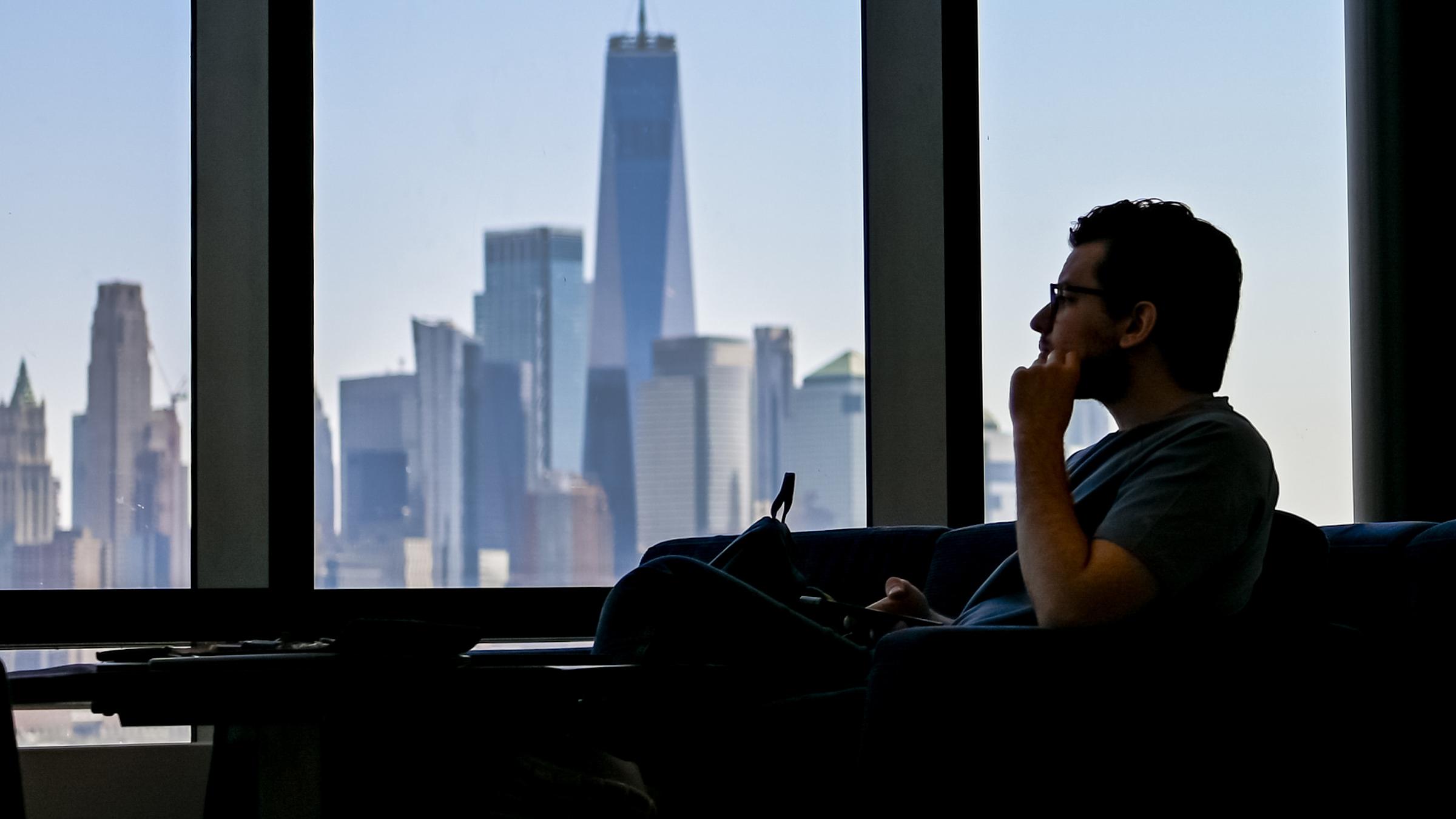 Student looks out window of UCC at New York skyline.