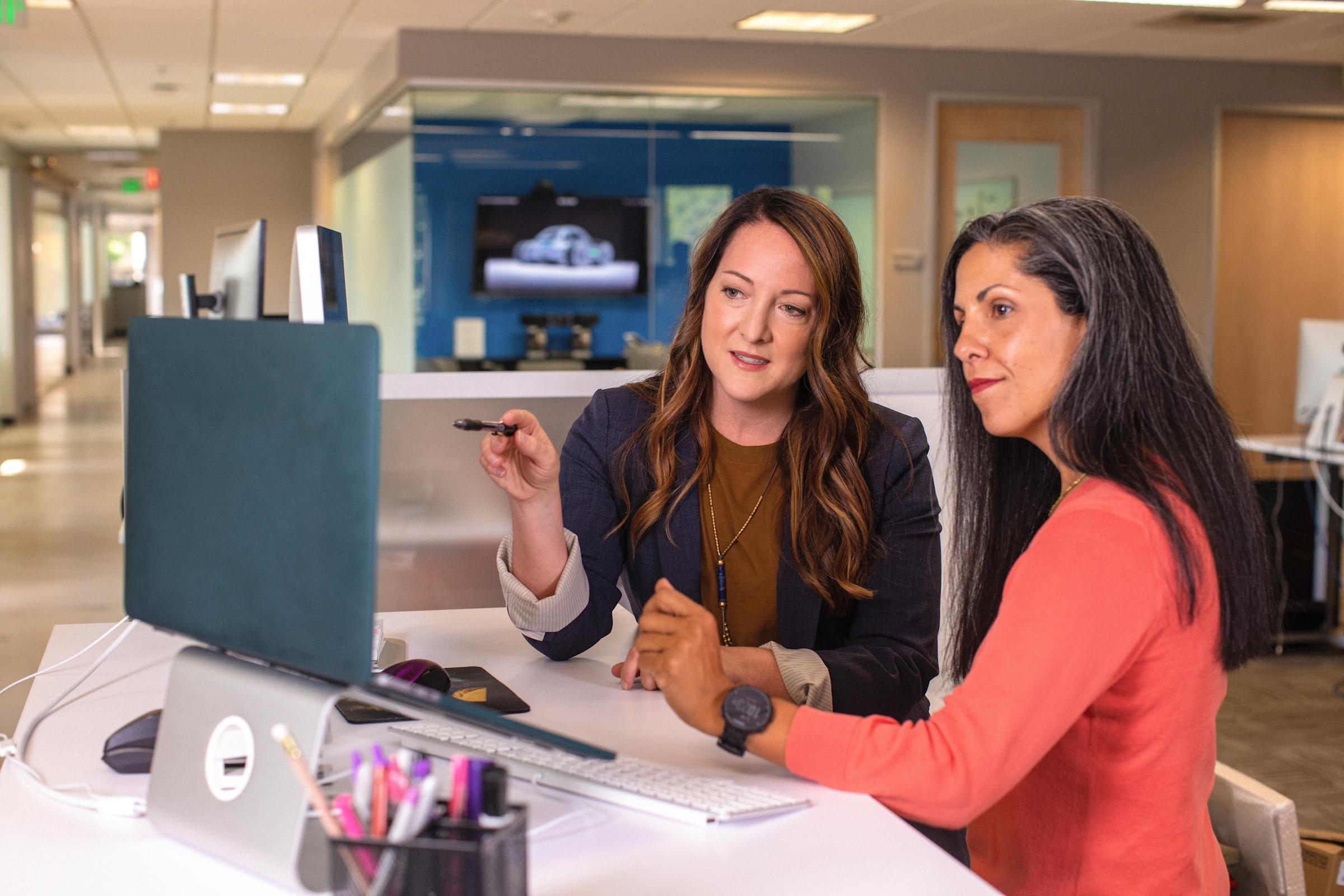 two women in a company office at a computer screen