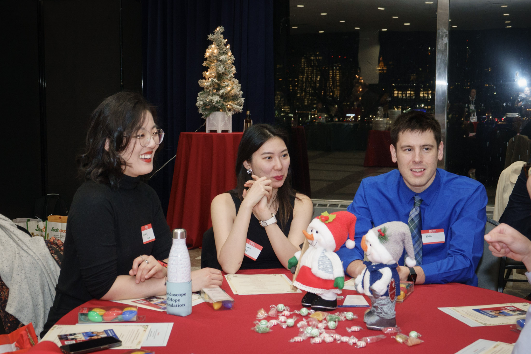 Three students sit at table with holiday decorations