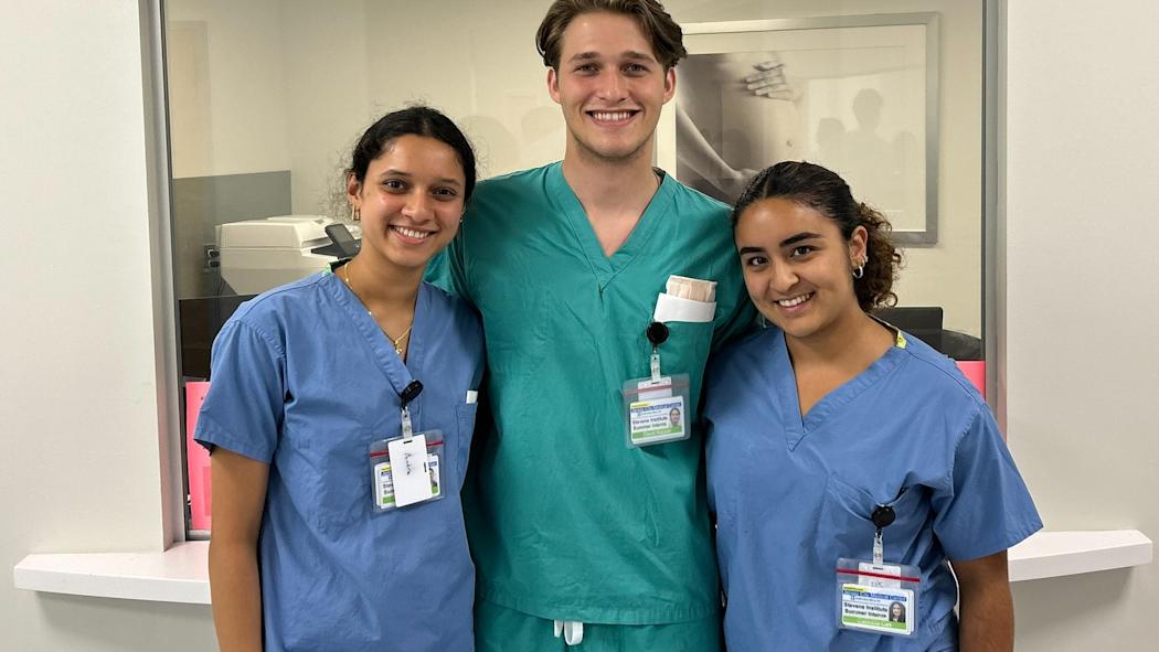 Three student OBGYN interns pose in front of a sign that reads Labor and Delivery.