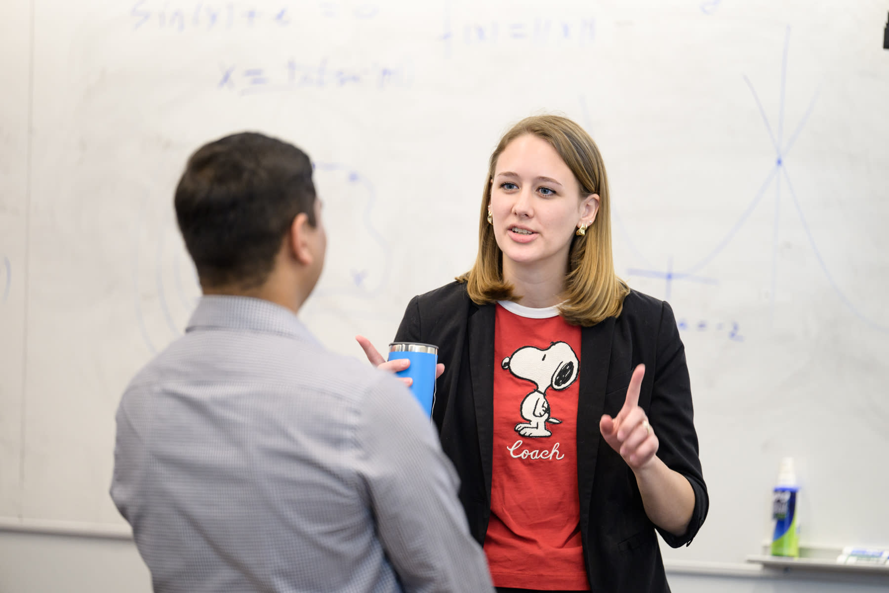 A man on the left and a woman on the right making hand gestures and having a conversation.