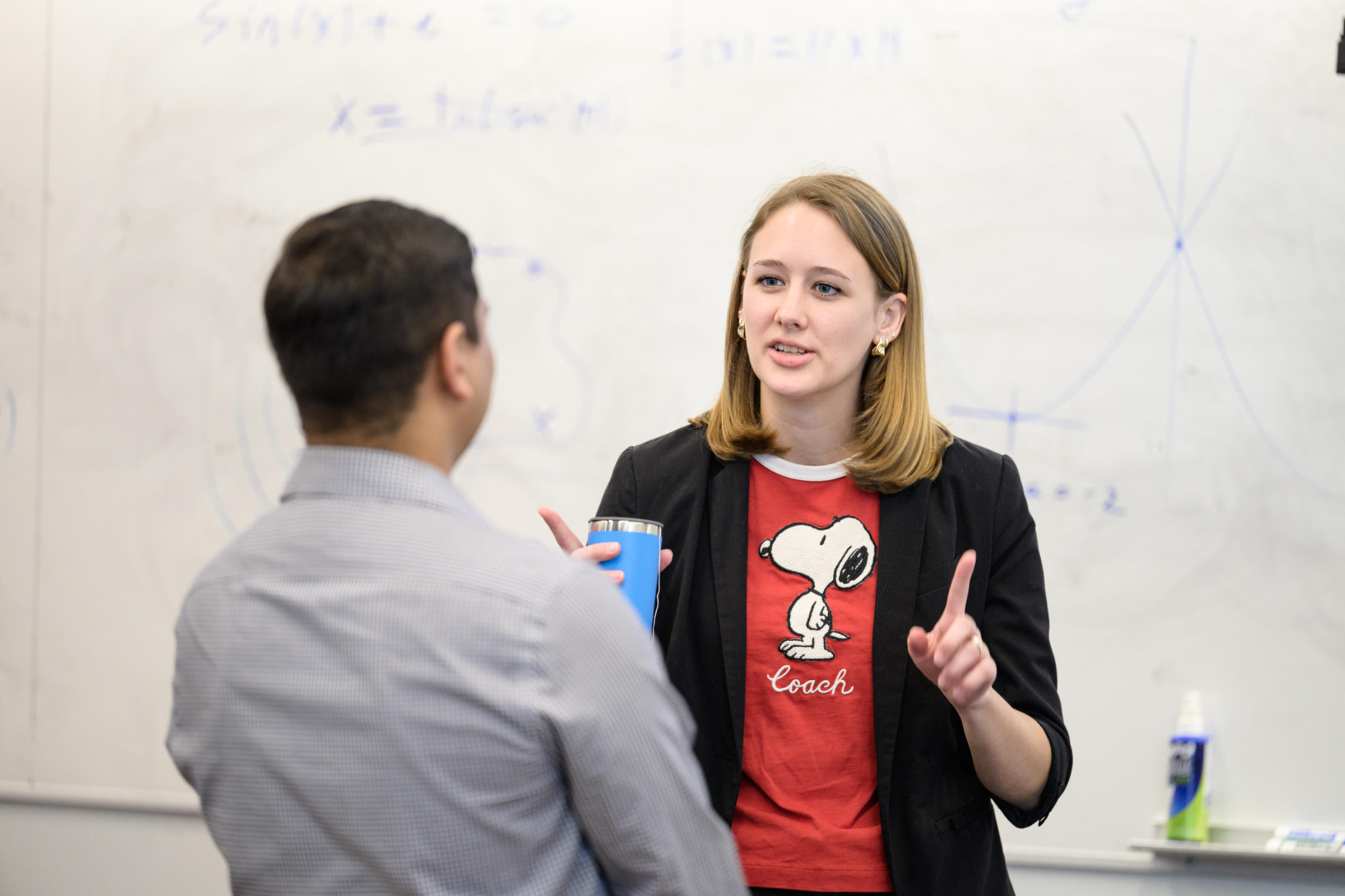 A man on the left and a woman on the right making hand gestures and having a conversation.