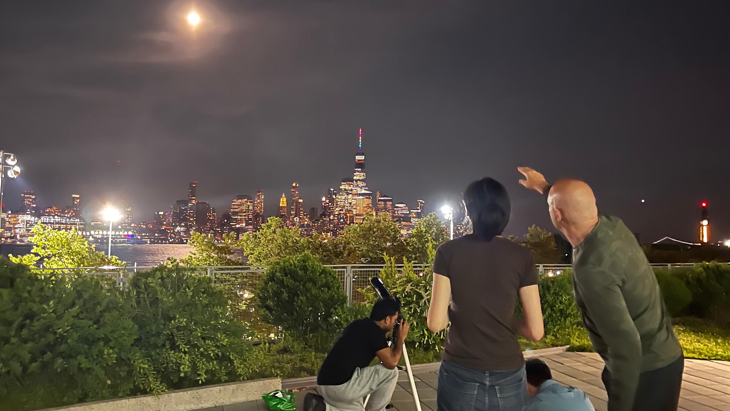 Ting Lu with telescope overlooking Manhattan
