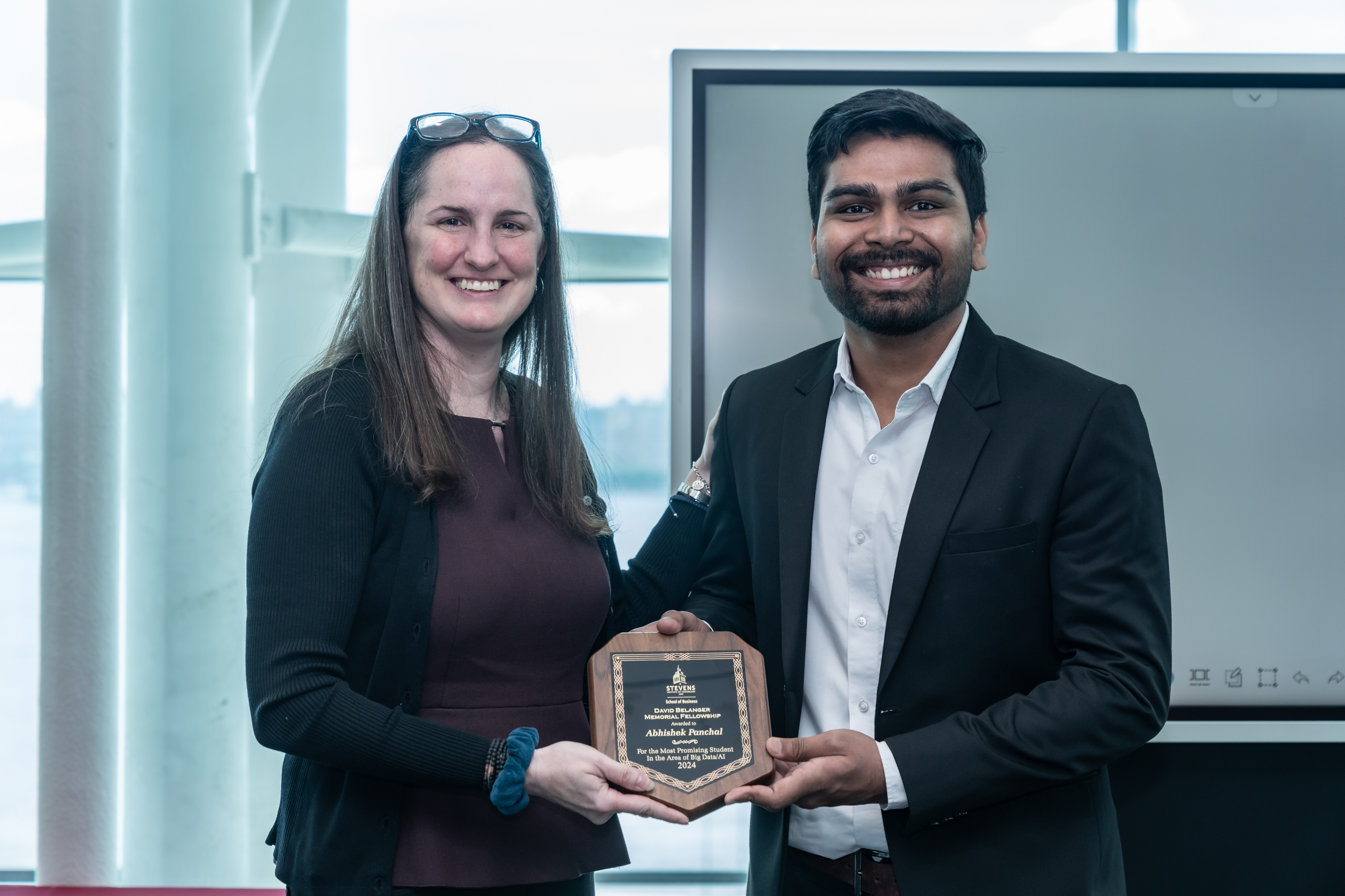 Recipient Abhishek Panchal stands next to David Belanger’s daughter, Erin Blackwell, holding his award