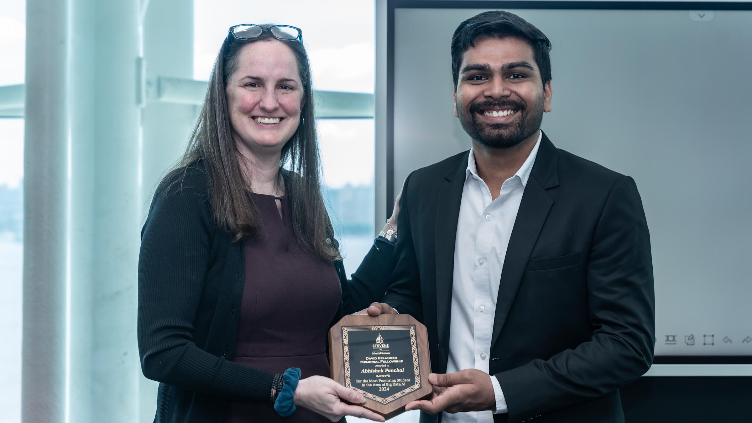 Recipient Abhishek Panchal stands next to David Belanger’s daughter, Erin Blackwell, holding his award