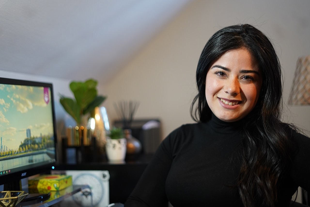 Jennifer Ramirez in her home office. The Stevens campus is visible on her desktop computer screen.