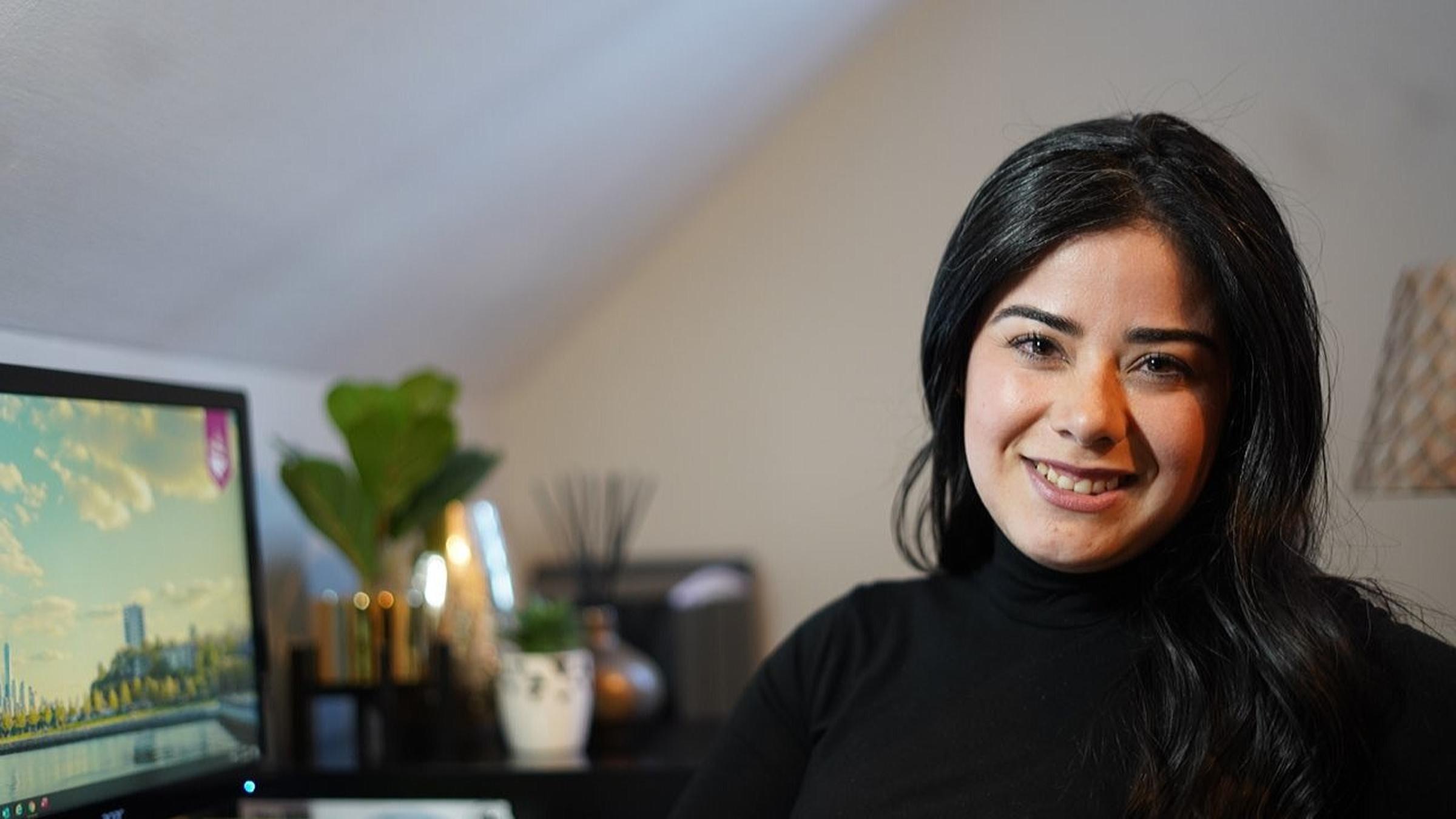 Jennifer Ramirez in her home office. The Stevens campus is visible on her desktop computer screen.