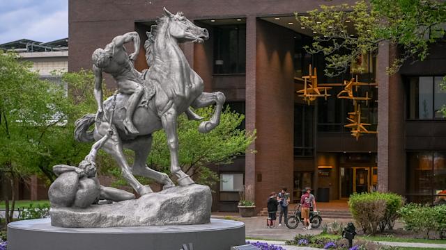 Torch Bearer sculpture on Stevens campus, depicting a man on horseback handing torch to another on ground.