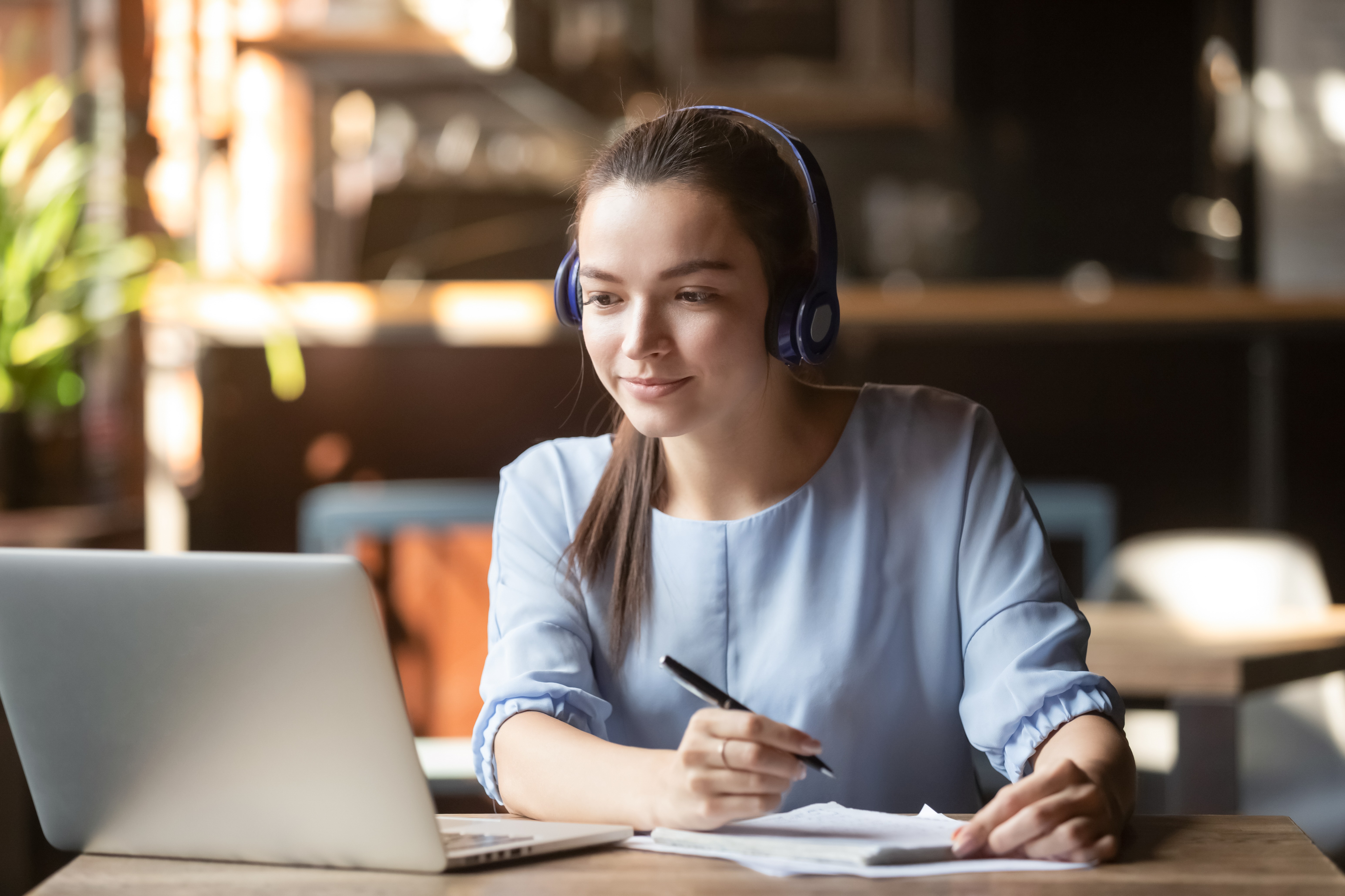 woman with laptop taking notes