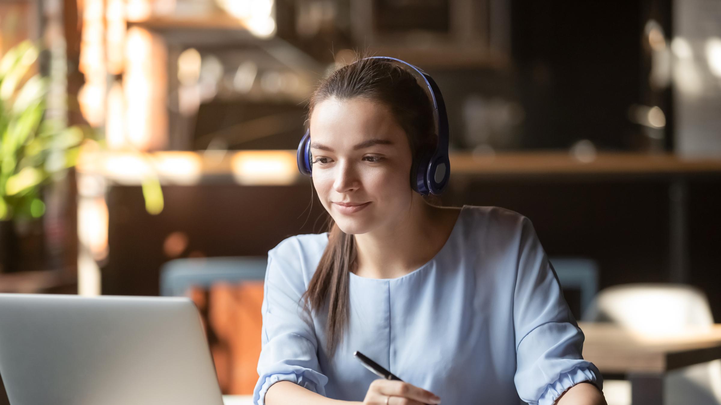 woman with laptop taking notes
