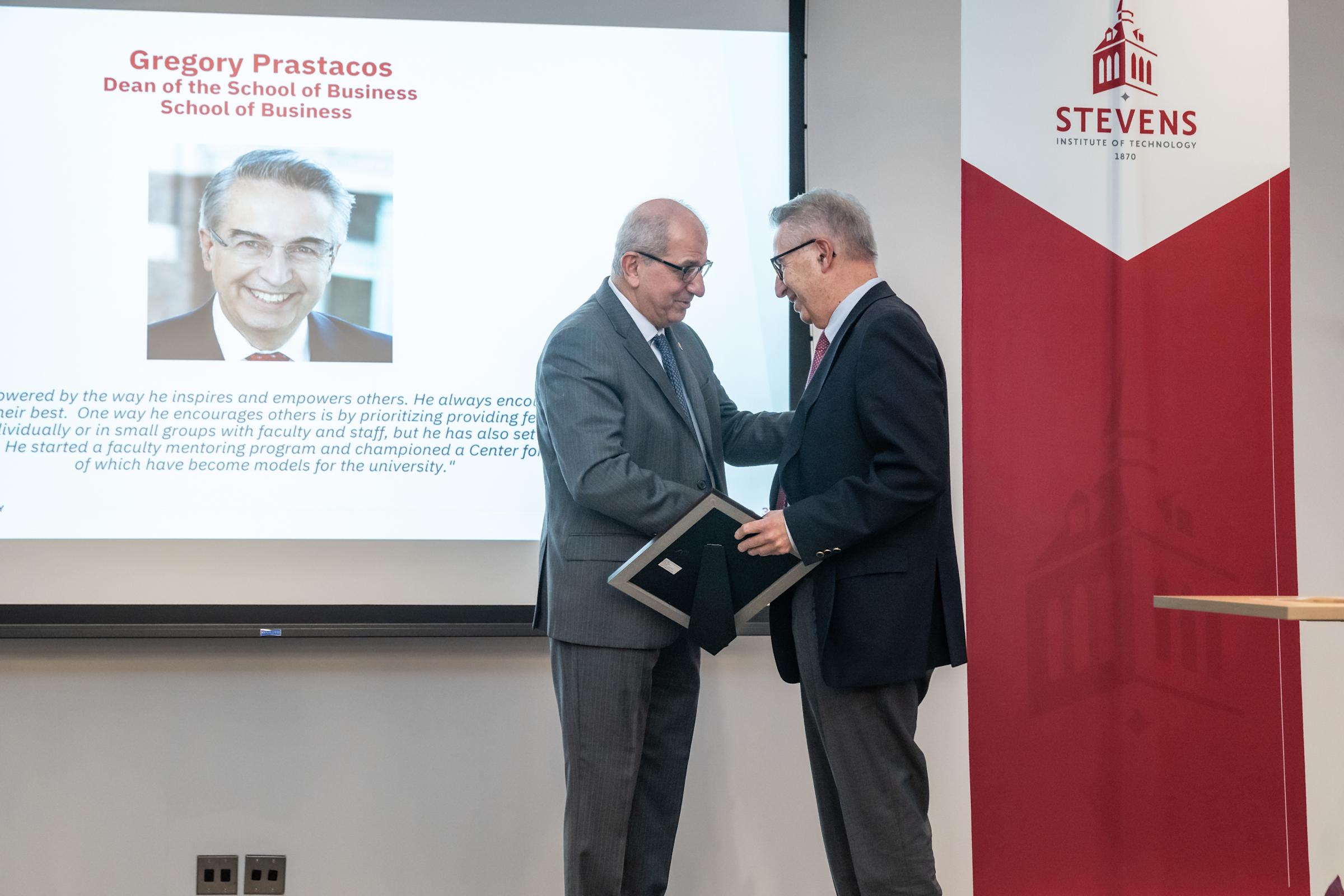 Gregory Prastacos shakes hands with President Farvardin on stage.