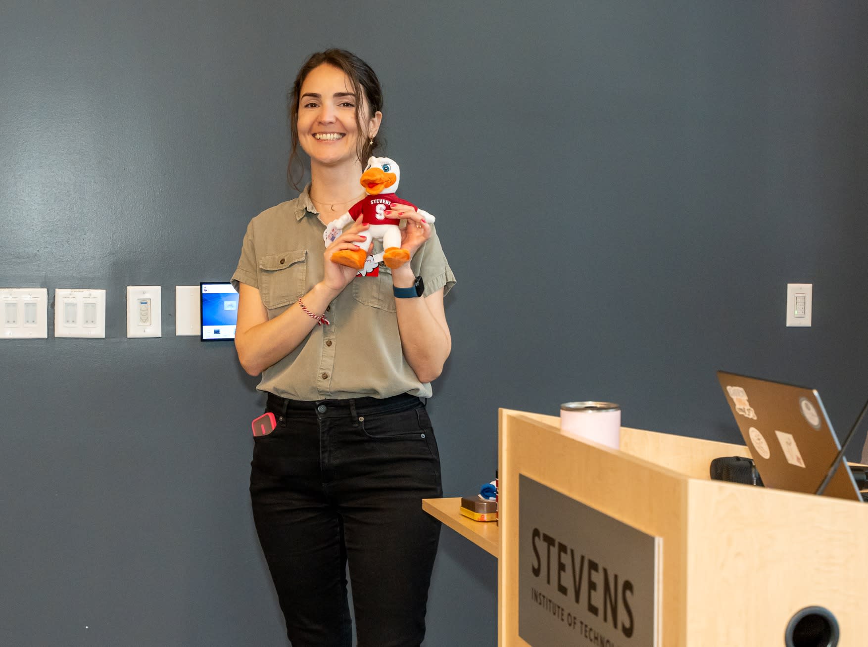 Gizem Acar posing with a Stevens Duck in front of a chalkboard.