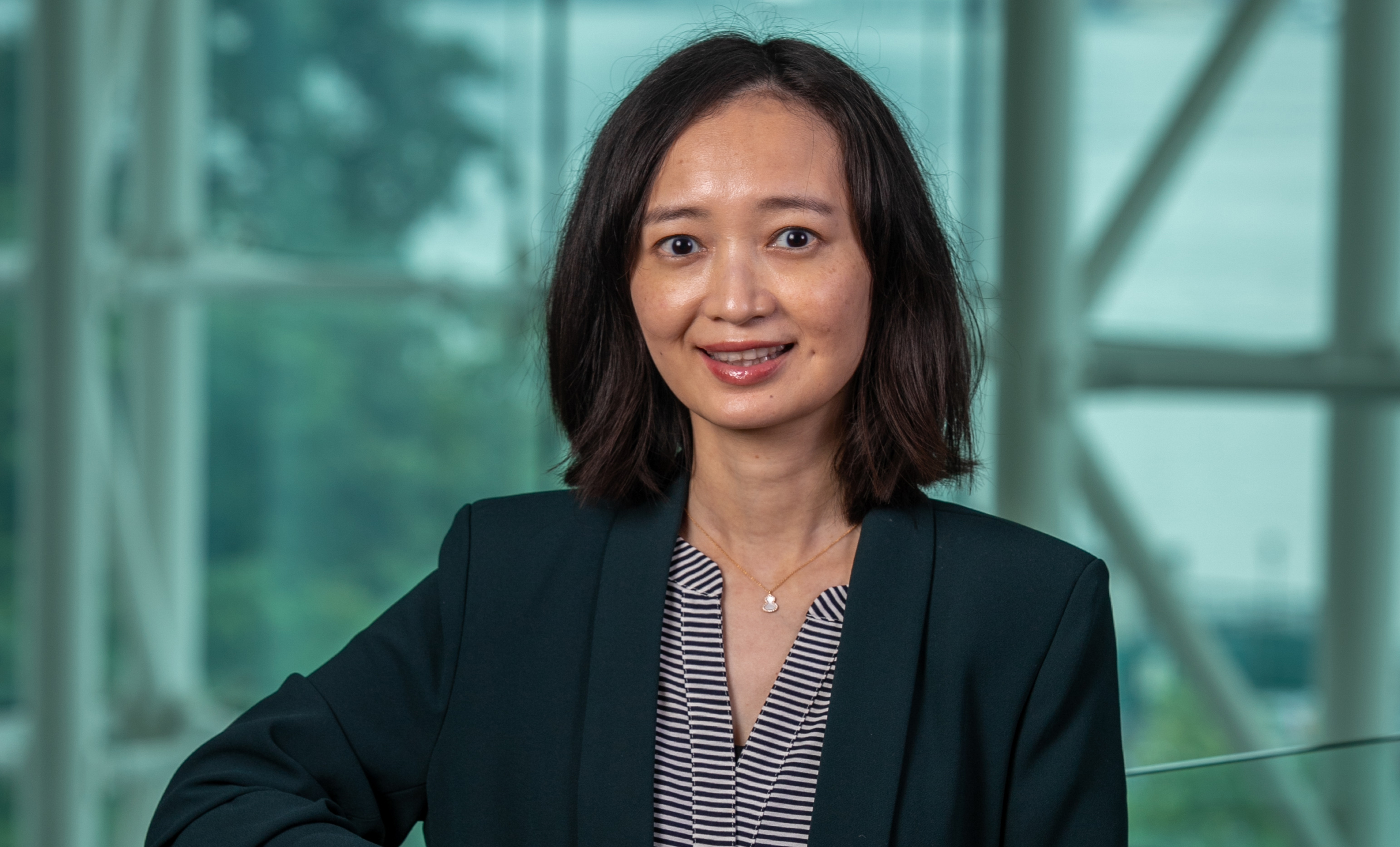 Bei Yan stands in the Babbio Center.