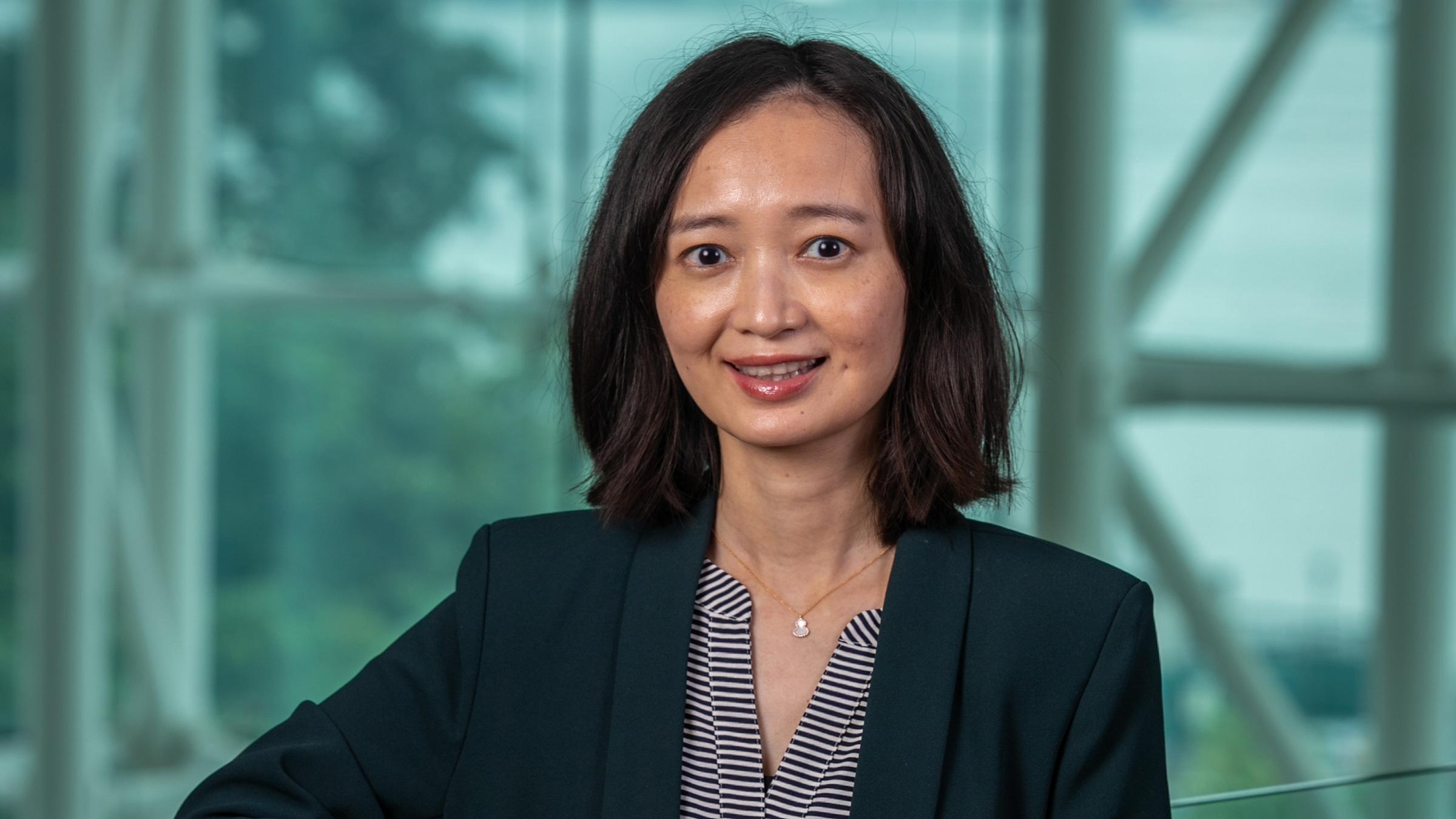 Bei Yan stands in the Babbio Center.