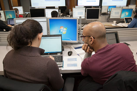 A professor working with graduate students on a computer