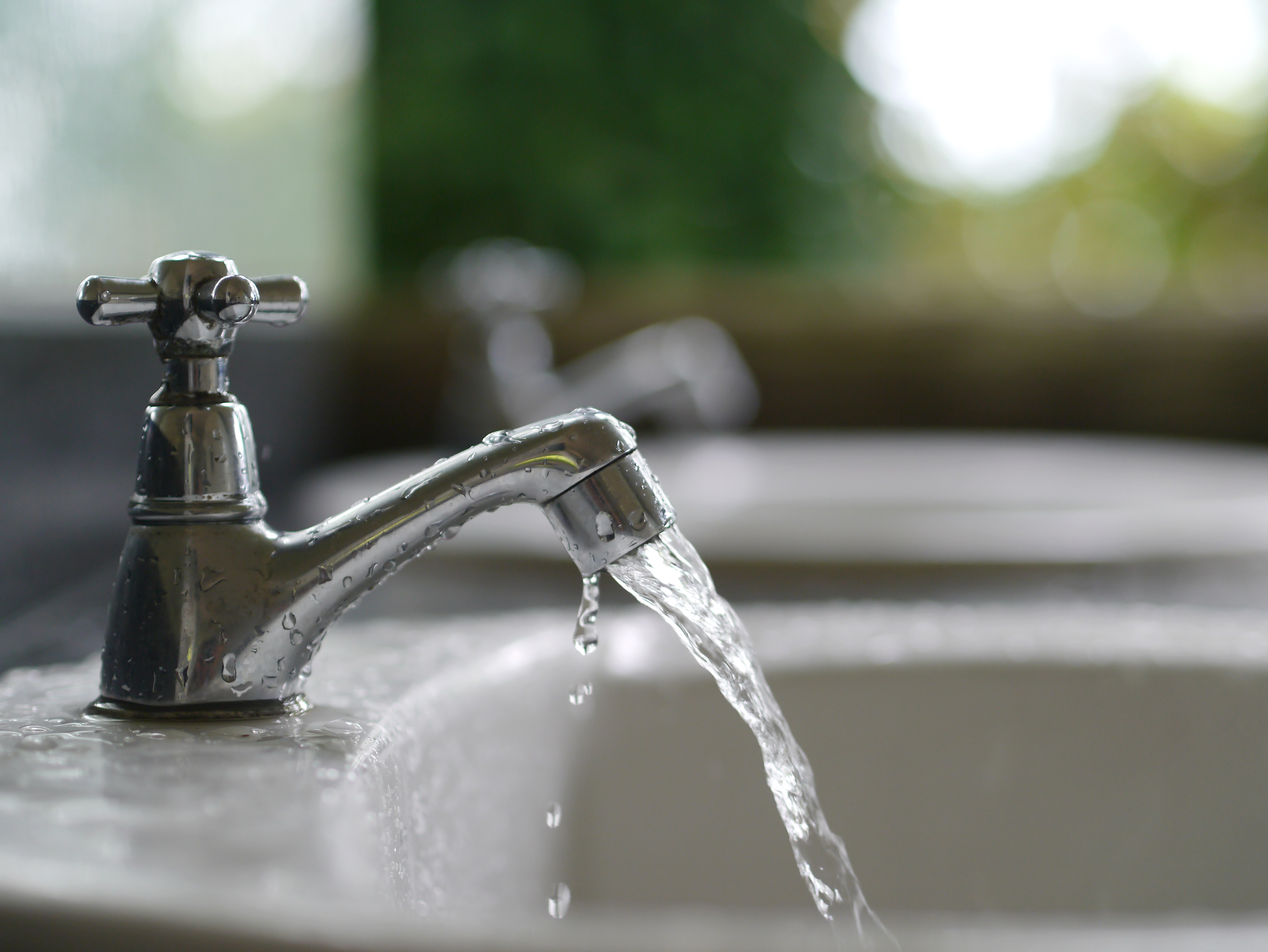water flowing out of a faucet into a sink